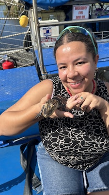 Chamidae holds a baby alligator in Barataria