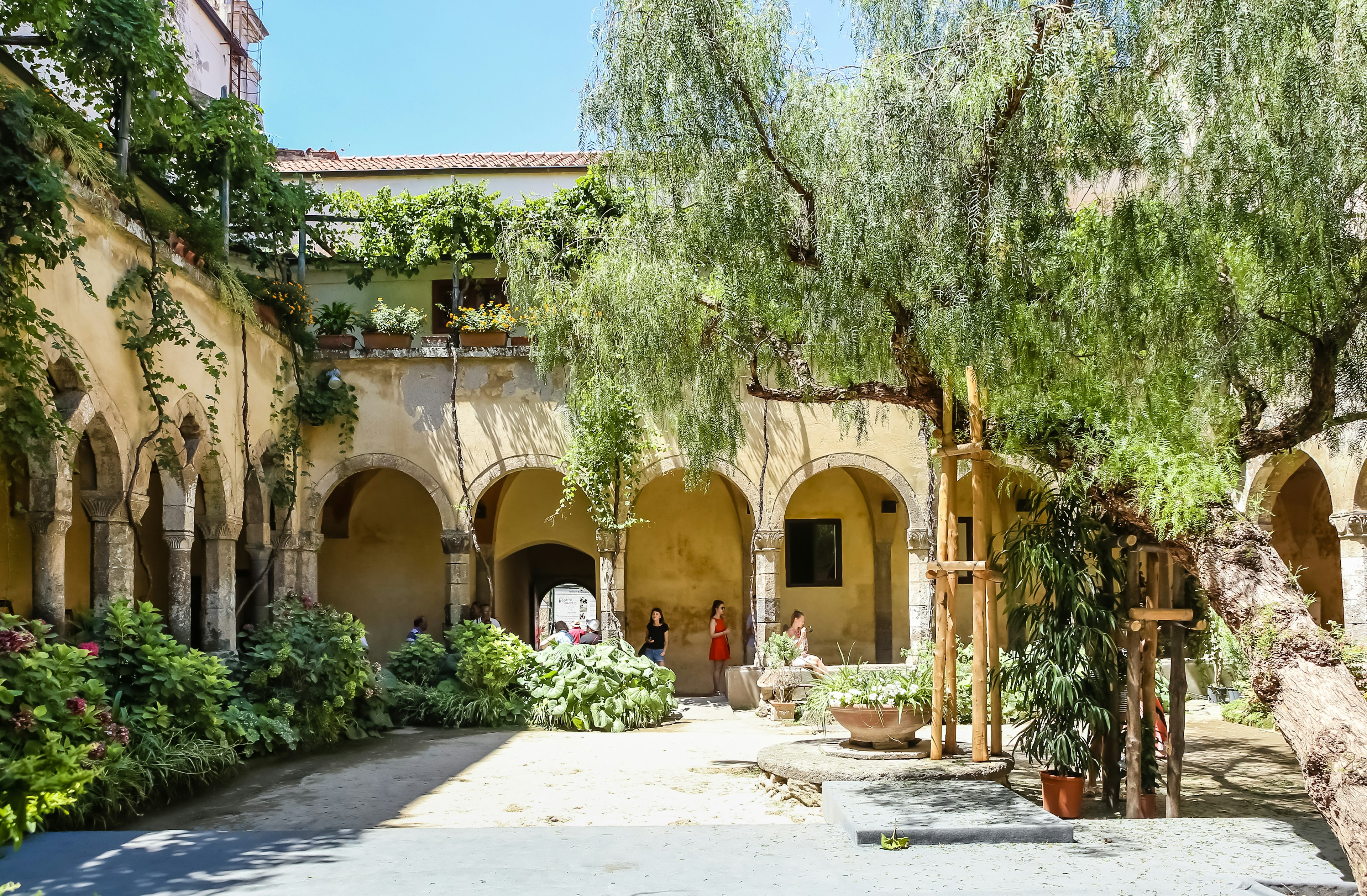 People wander through the interior courtyard of an Italin church.