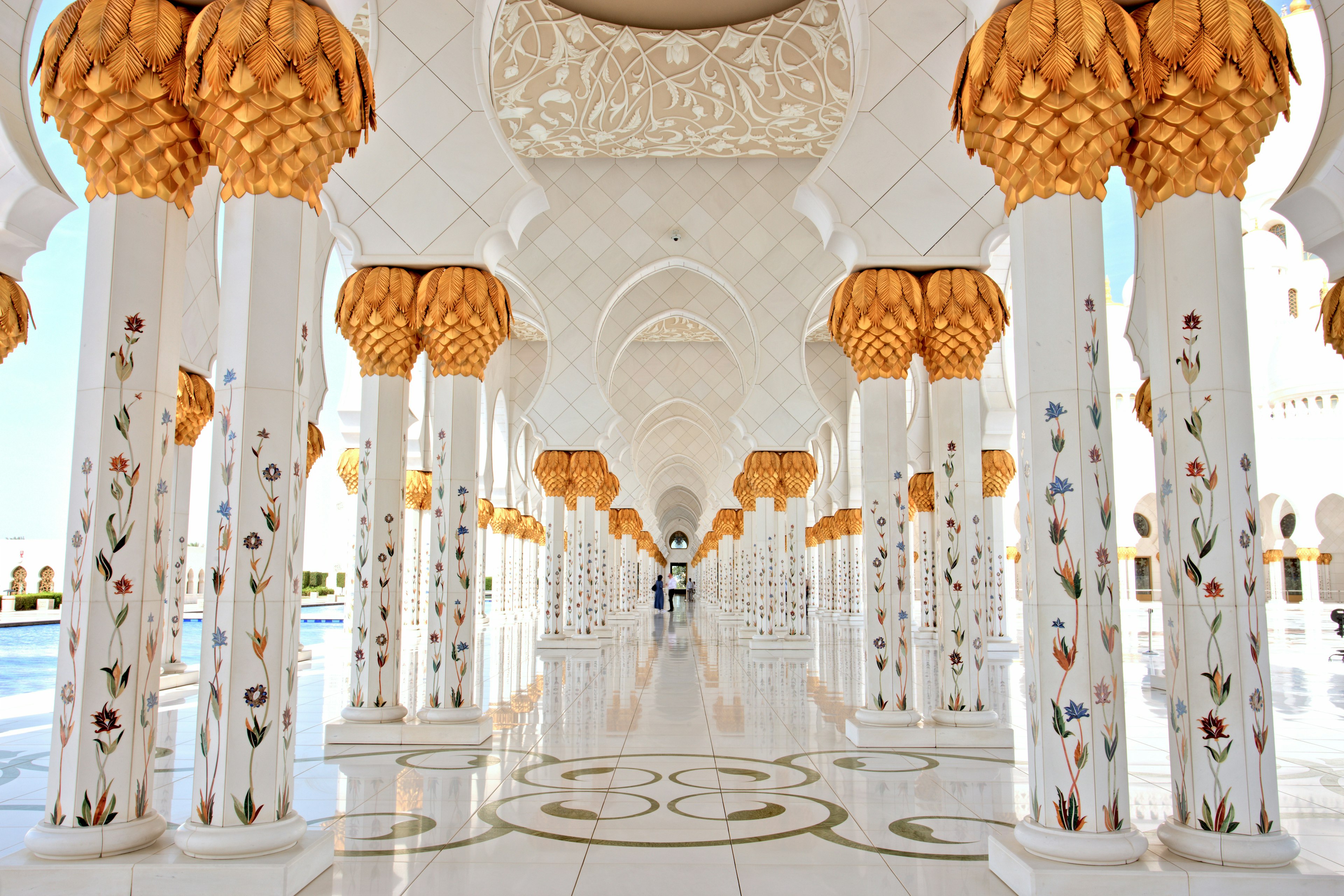 Elaborate columns, made of white marble with patterns of inlaid stones, form a corridor