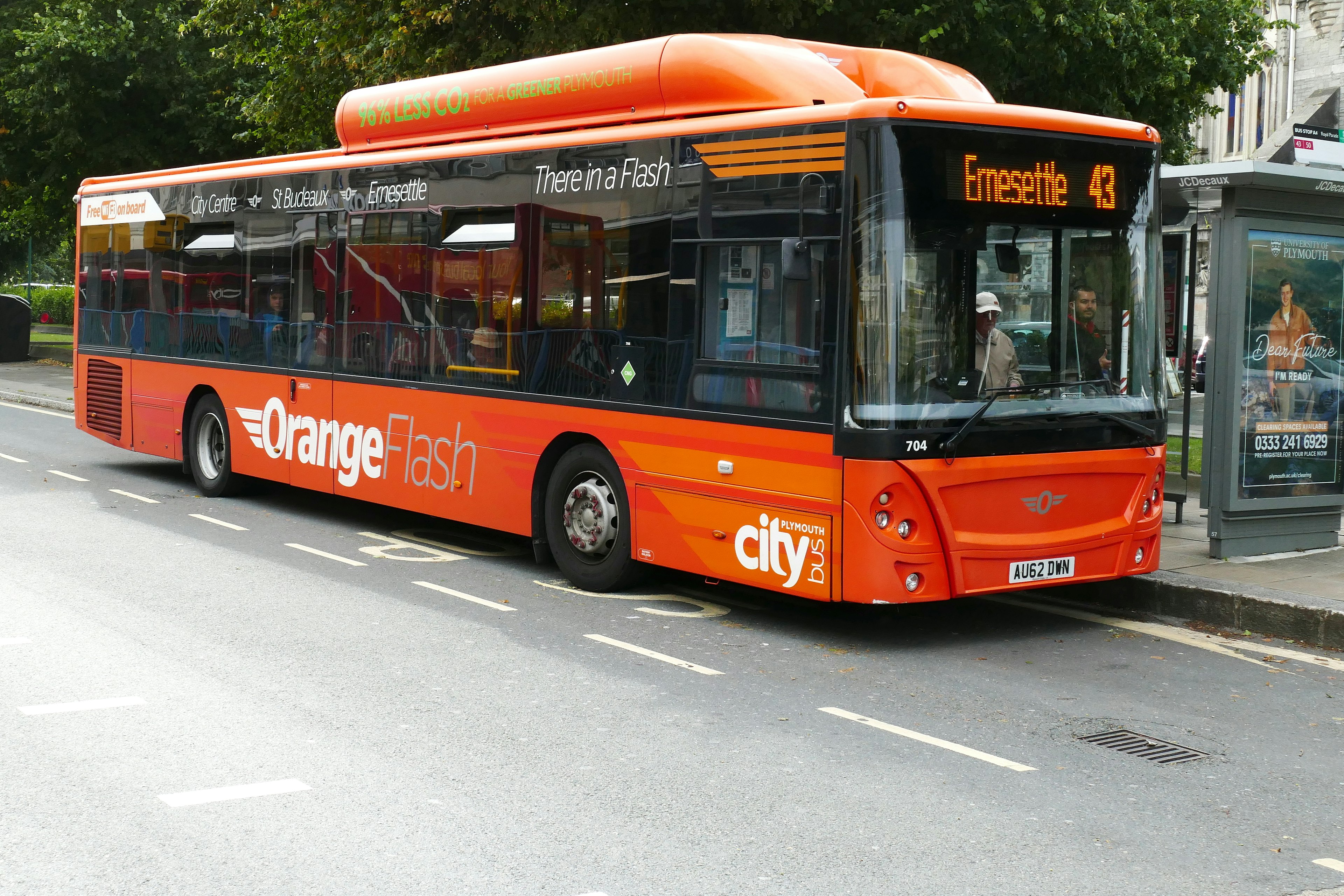 Plymouth England.Single deck public transport bus powered by compressed natural gas or CNG. Tank on roof with green writing stating gas powered. In use on road with passengers In city center.