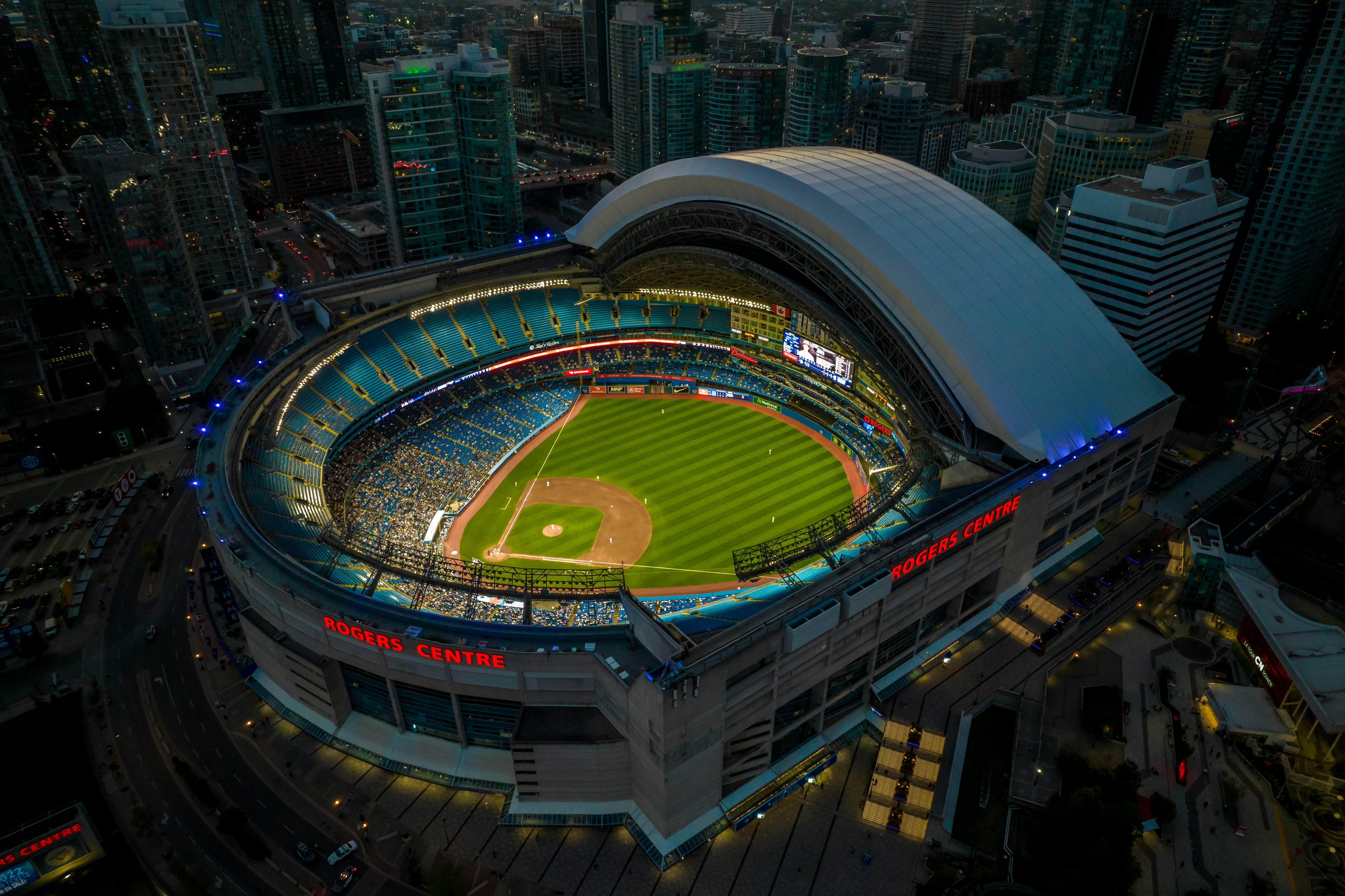 A stadium at night with a large baseball pitch and spectators in the stands