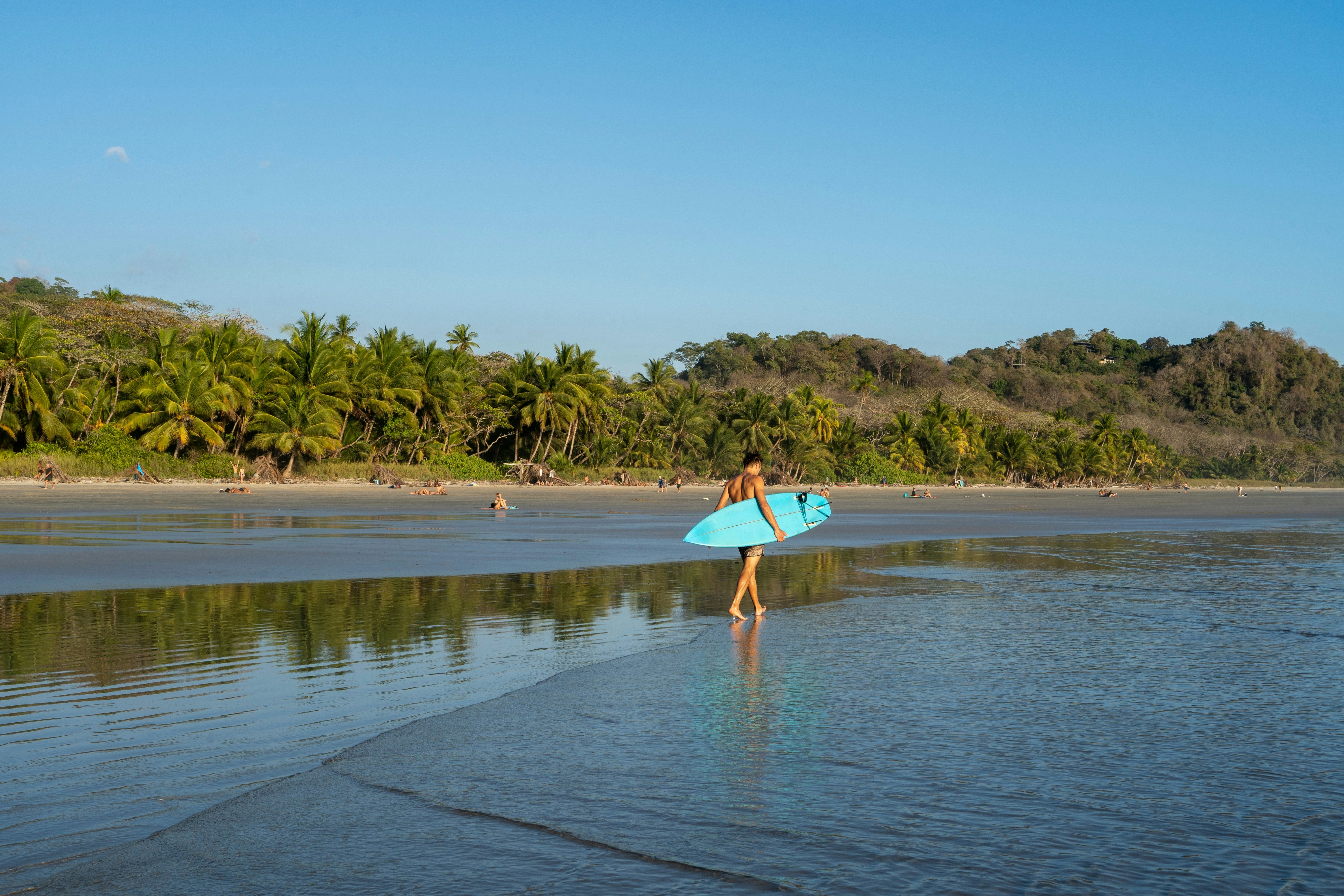 Surfer walking at the beach at Playa Hermosa.