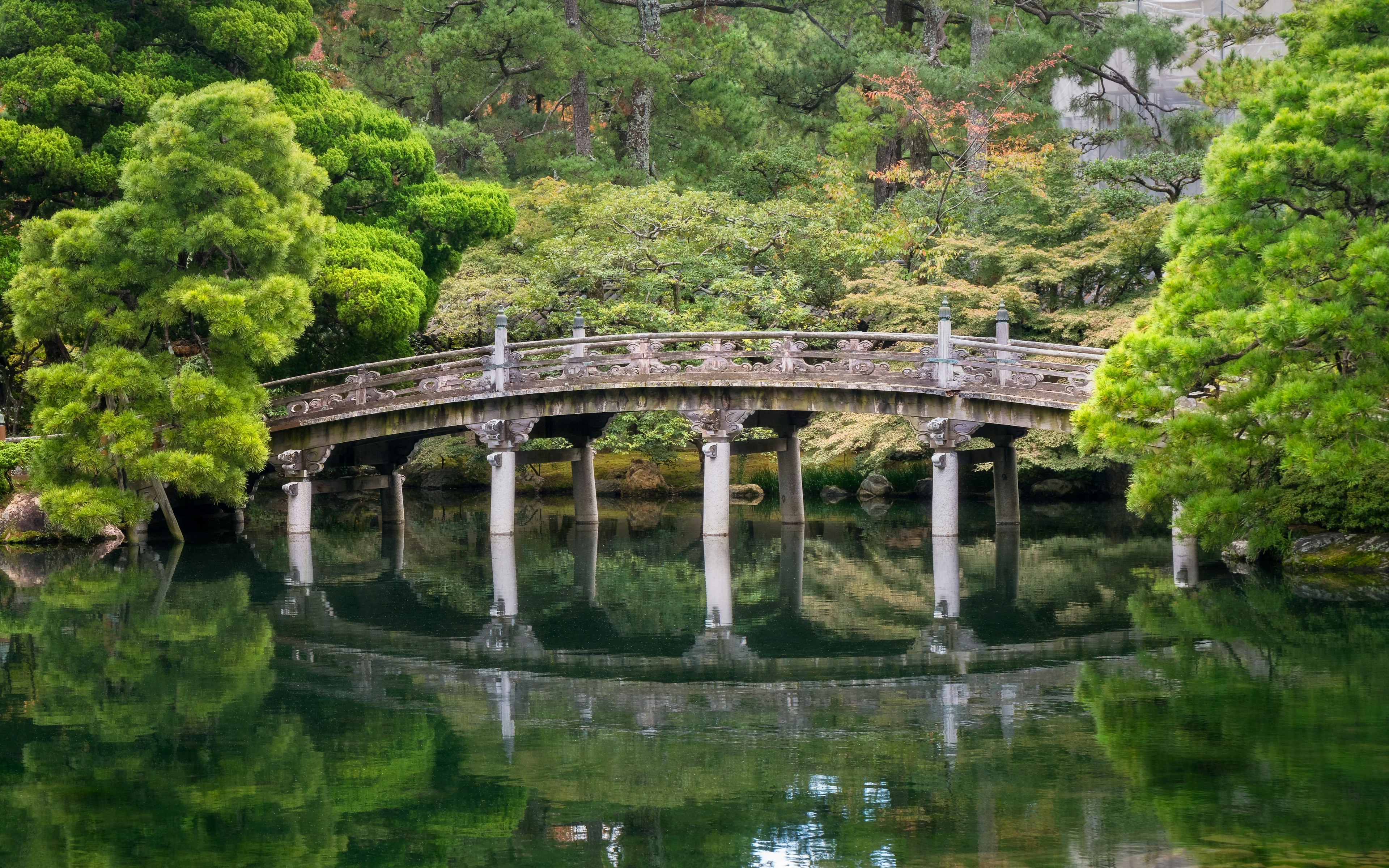 Historic stone bridge at Gonaitei garden on beautiful autumn day in Kyoto Imperial palace in Kyoto, Japan. Oike-niwa - serene japanese zen garden and pond