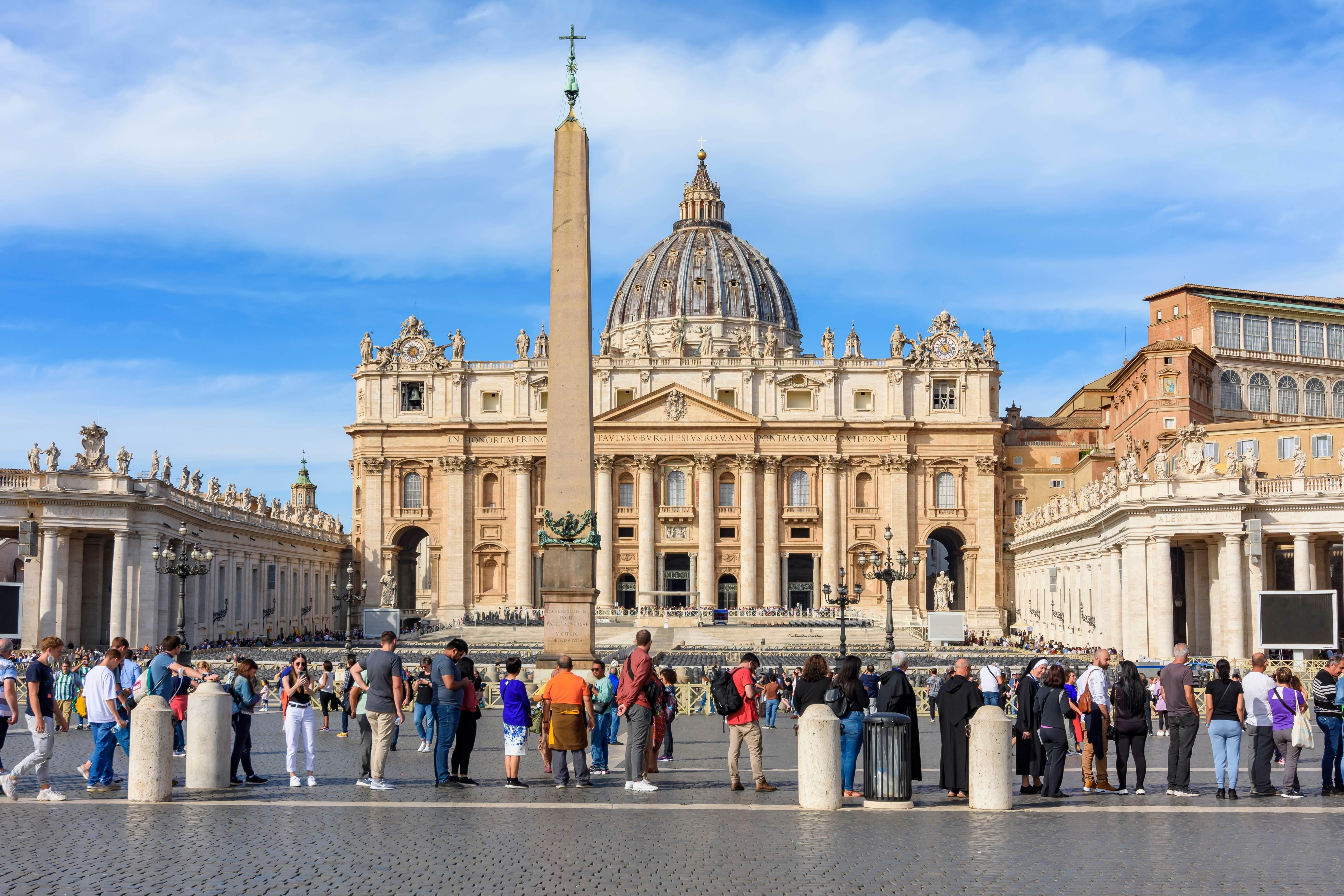 People standing in line to visit St. Peter's Basilica on St. Peter's square.