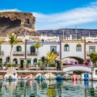 Traditional Colorful Buildings With Boats In Front And Mountain In The Background - Puerto de Mogan, Gran Canaria, Canary Islands, Spain  License Type: media  Download Time: 2024-06-24T04:59:25.000Z  User: meg3348277  Is Editorial: No  purchase_order: 56530