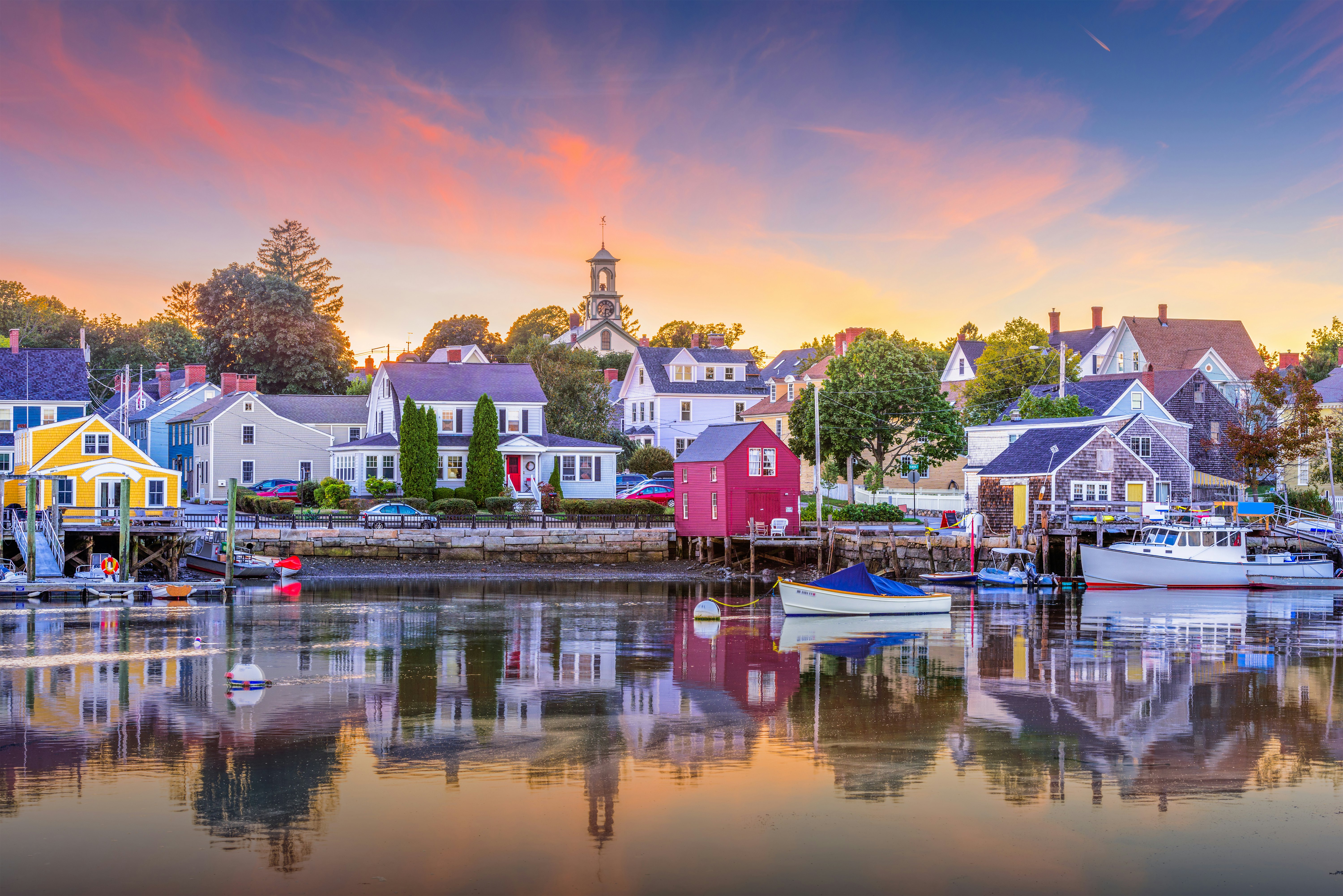 A small harbor in a town of colorfully painted houses at sunset