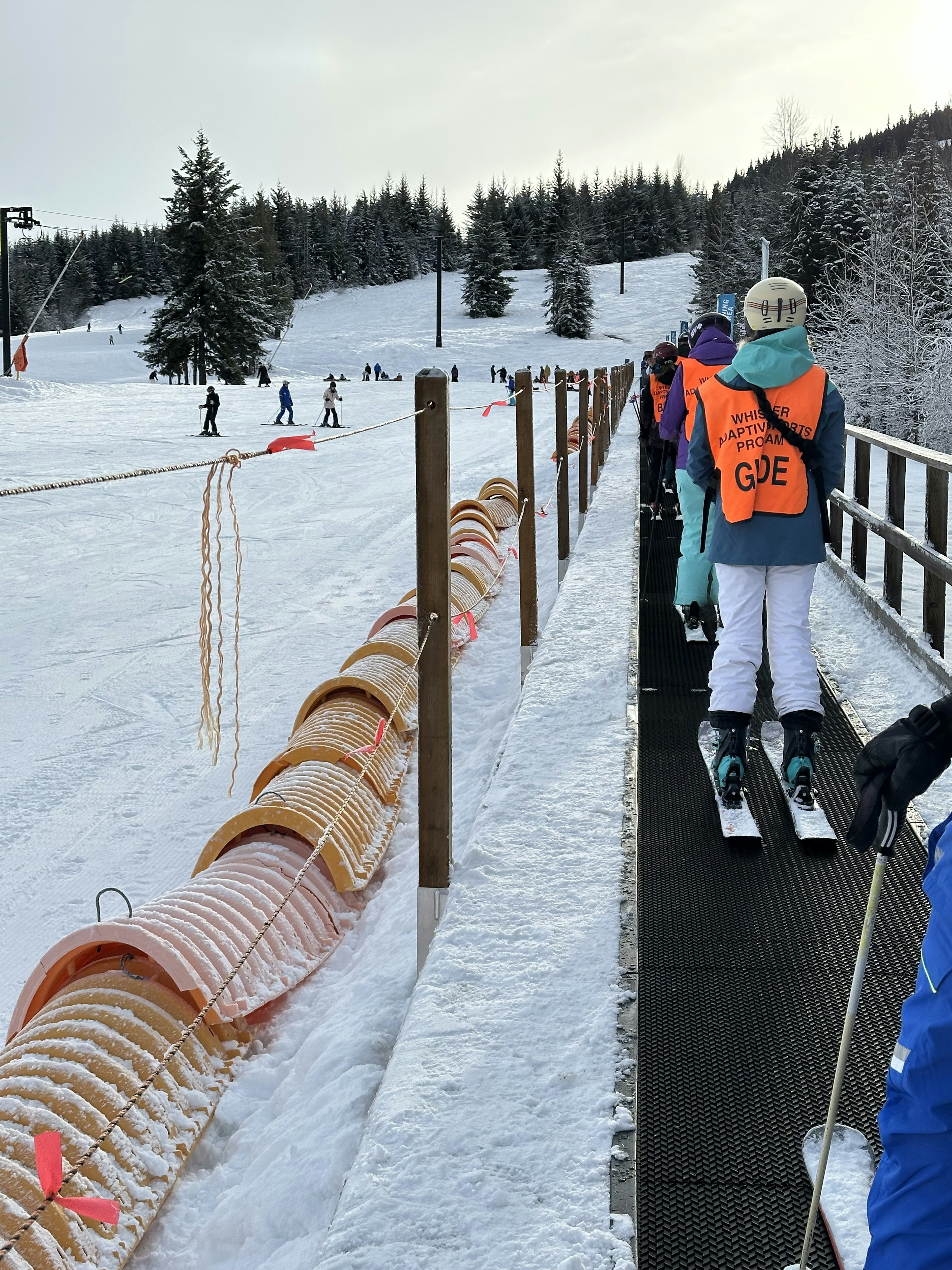 Adaptive guides (in orange vests) teaching ski lessons on Whistler Blackcomb.