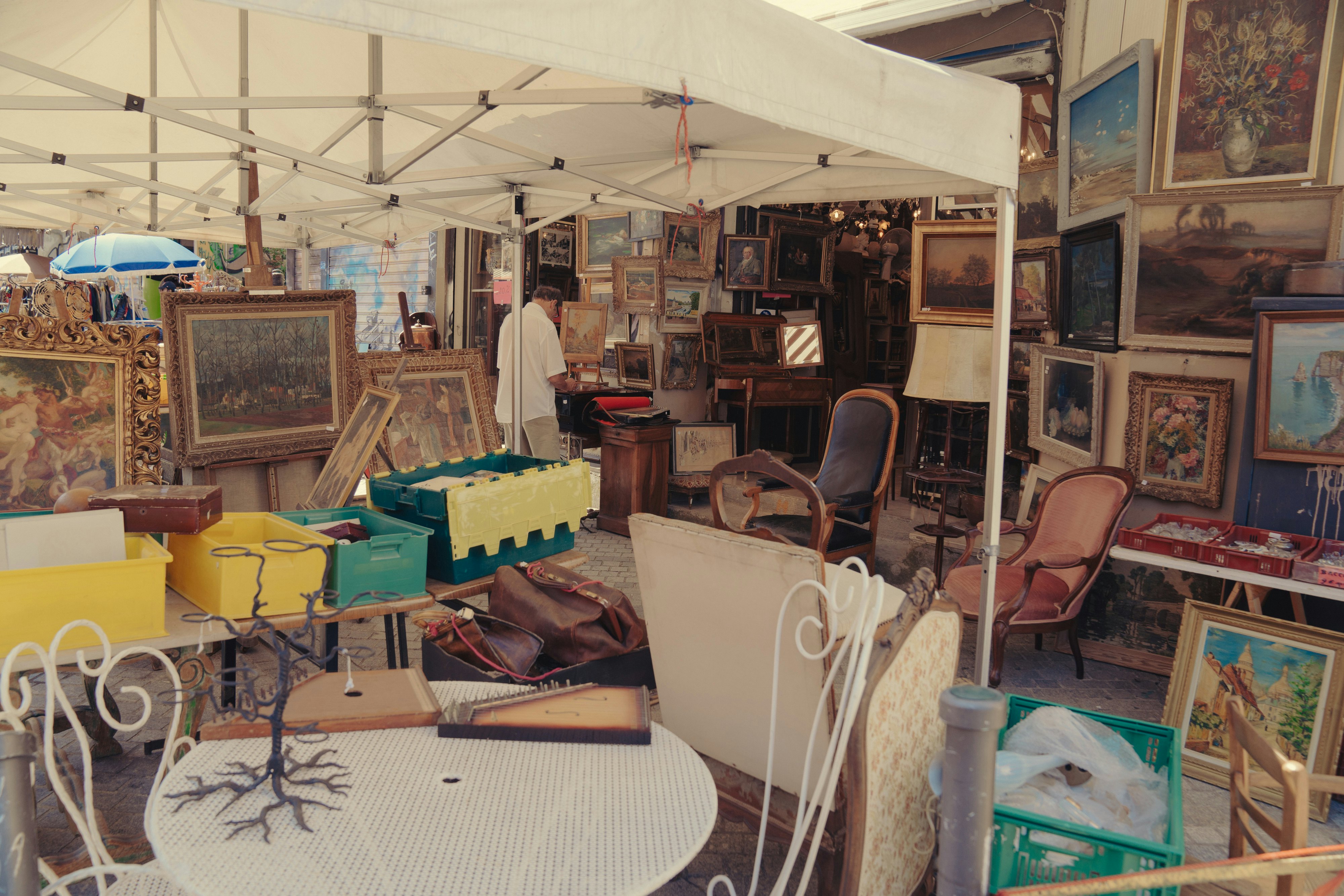 A market stall loaded with furniture and paintings