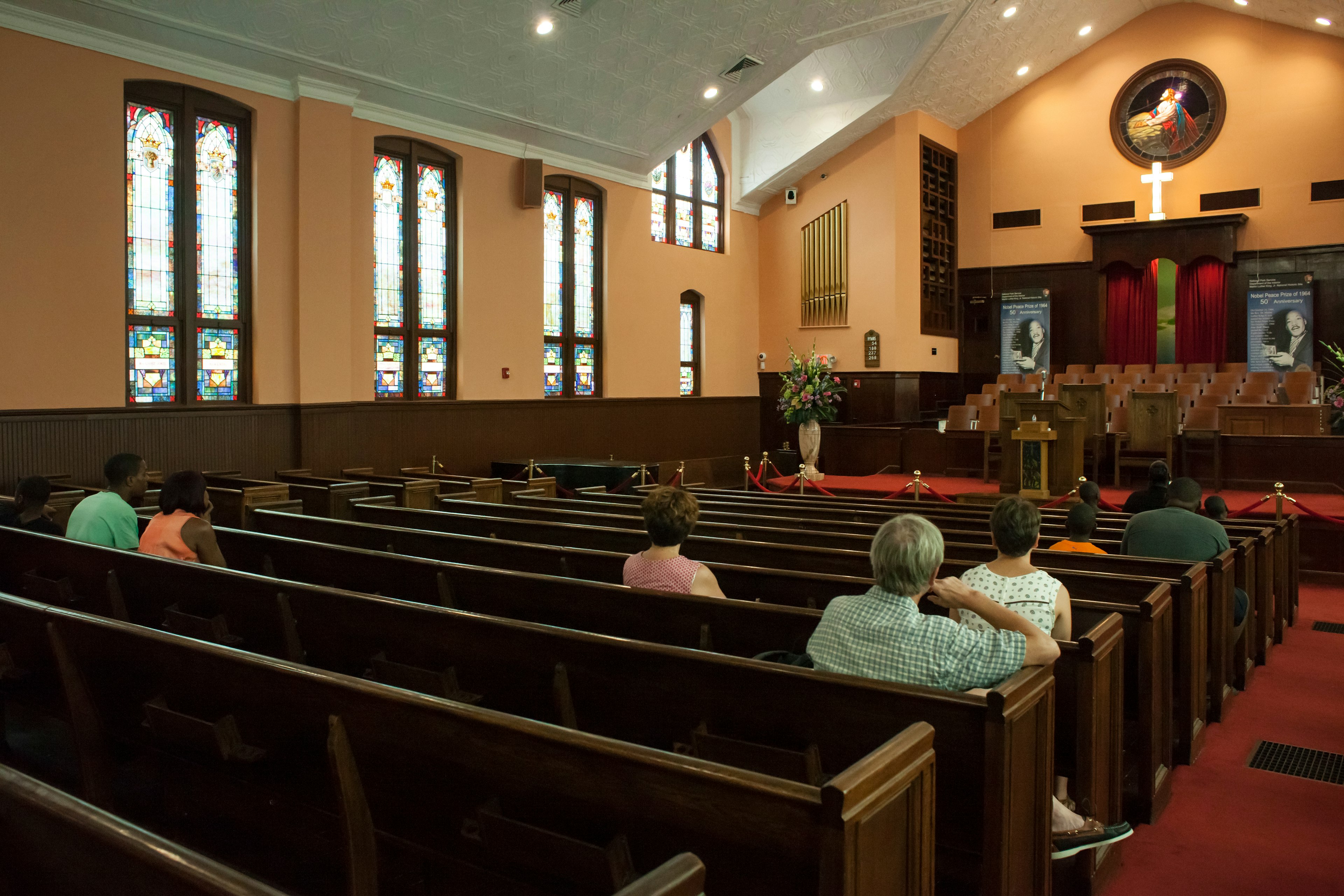 People are seeing from behind sitting in pews in the sanctuary of a church