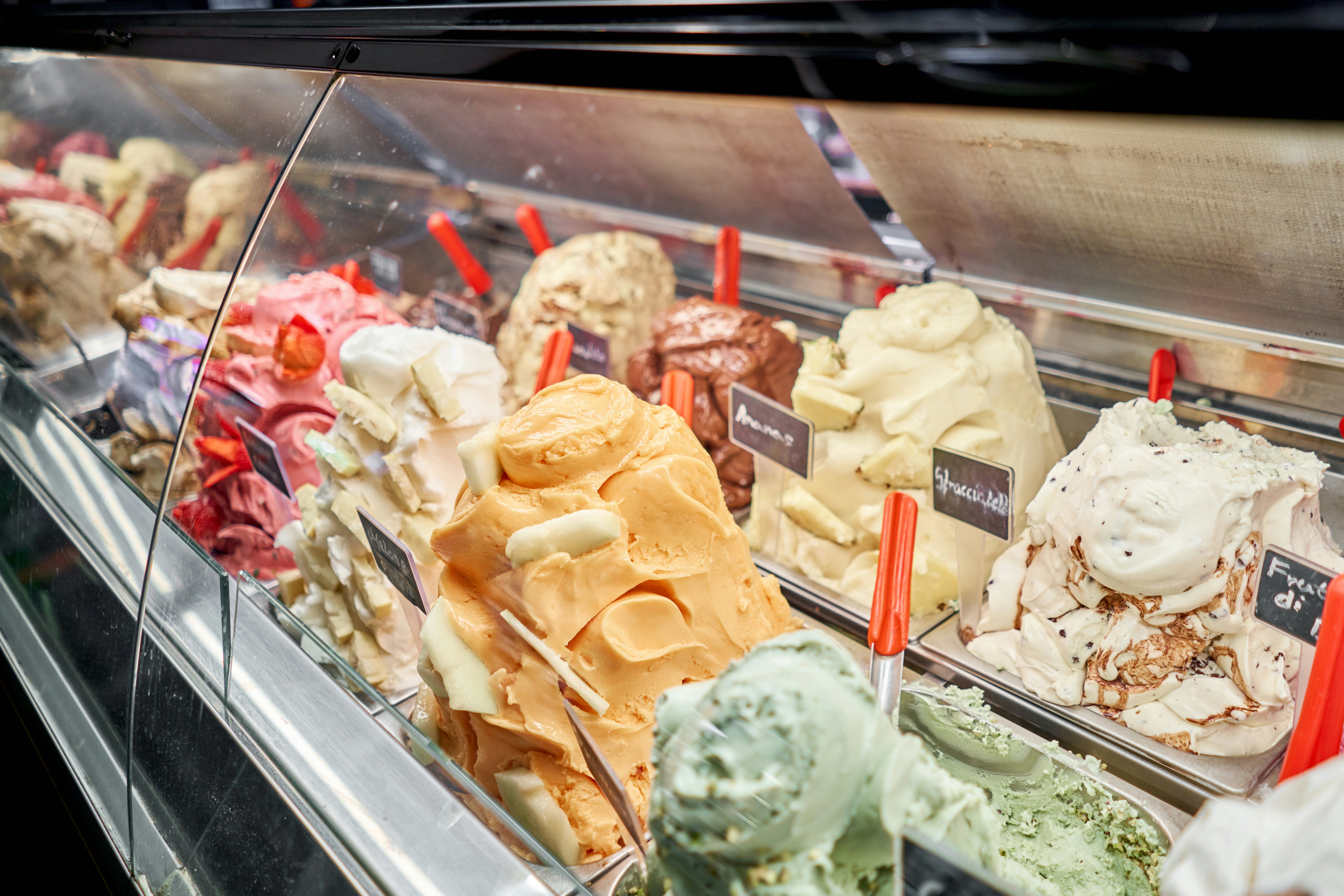 A counter of gelato in various colors and flavors in Rome, Italy.