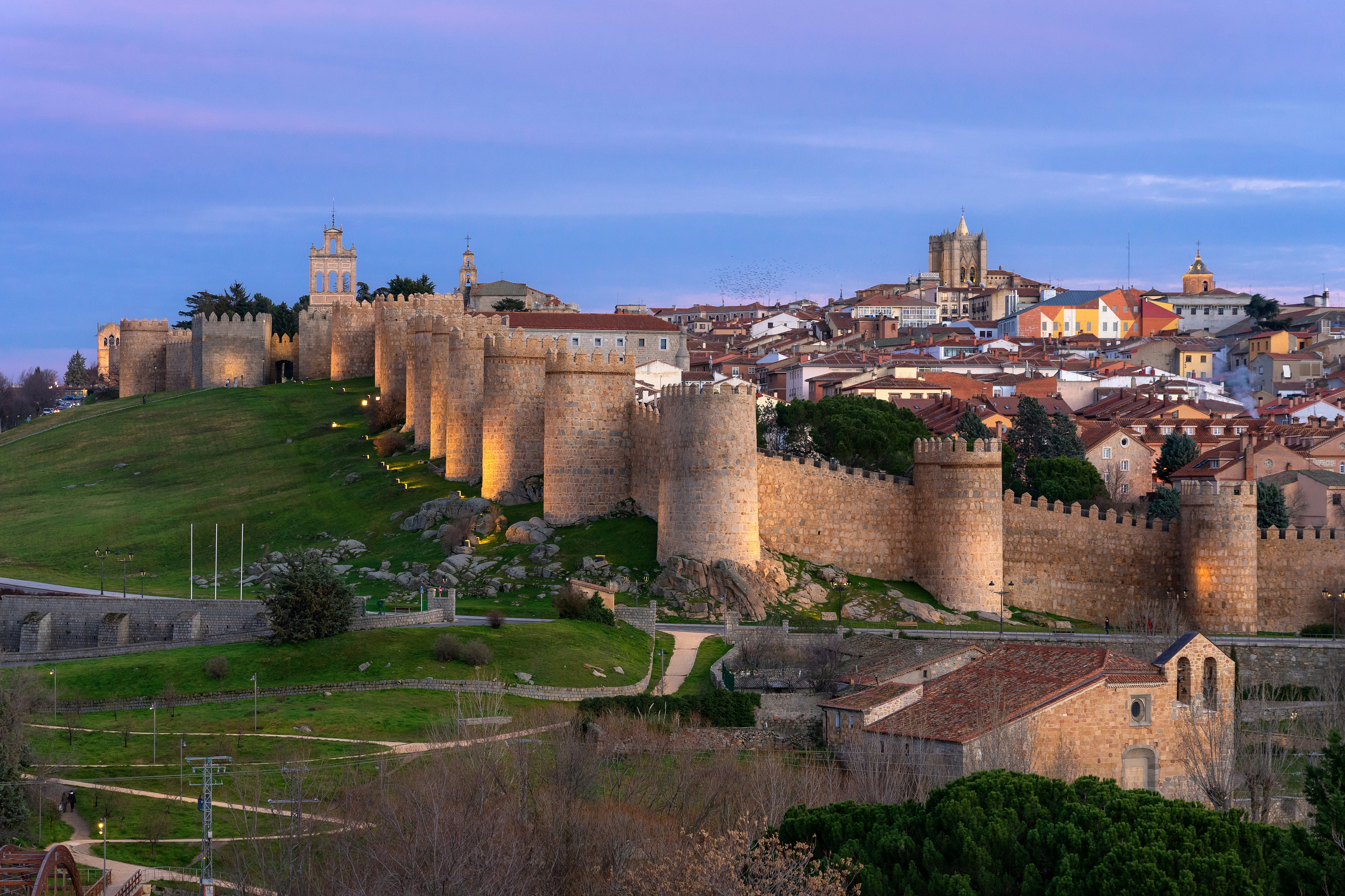 A view of the outer walls of the city of Ávila as the sun sets.