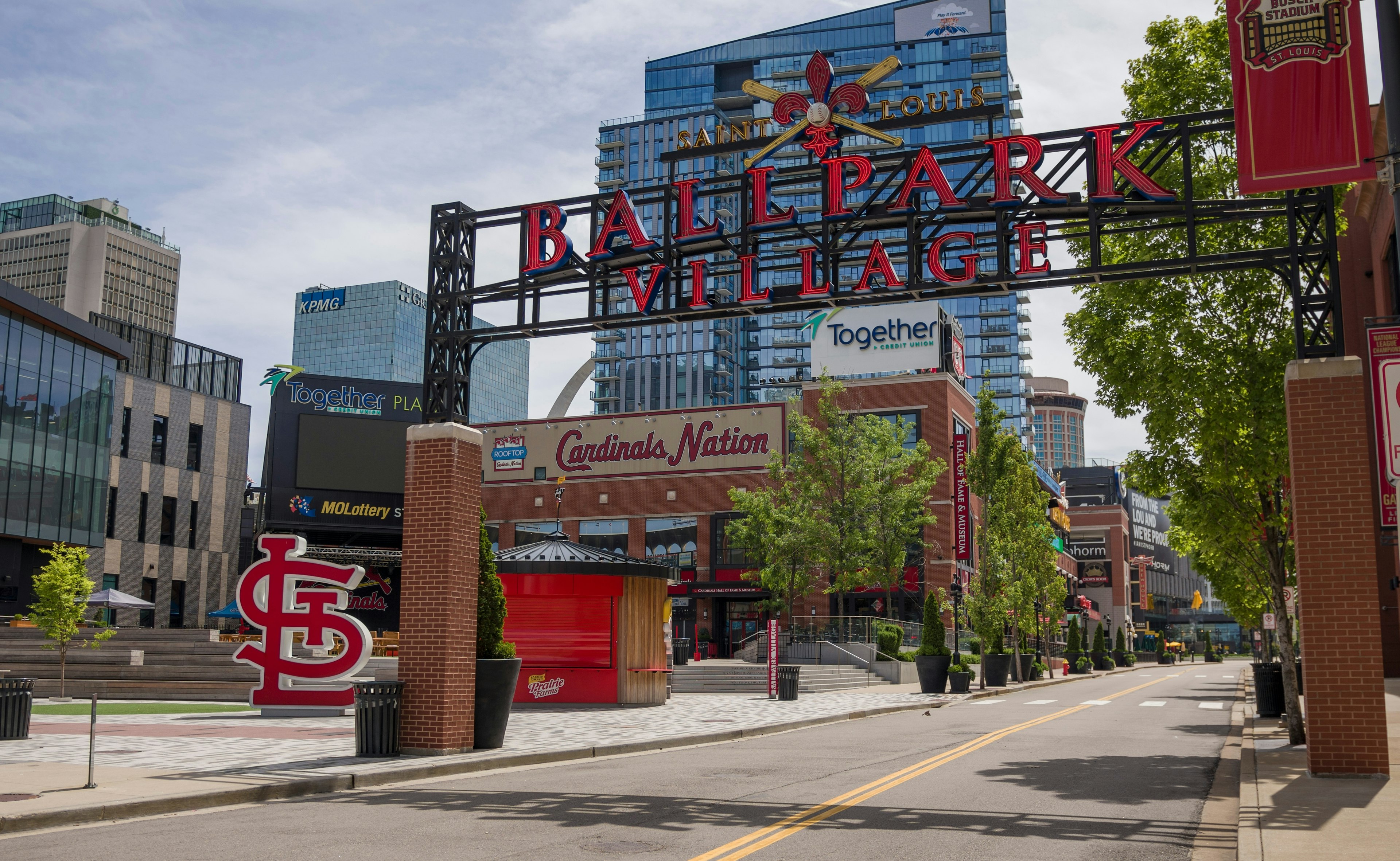 The entrance to a neighborhood with a large sign that says "Saint Louis Ballpark Village"