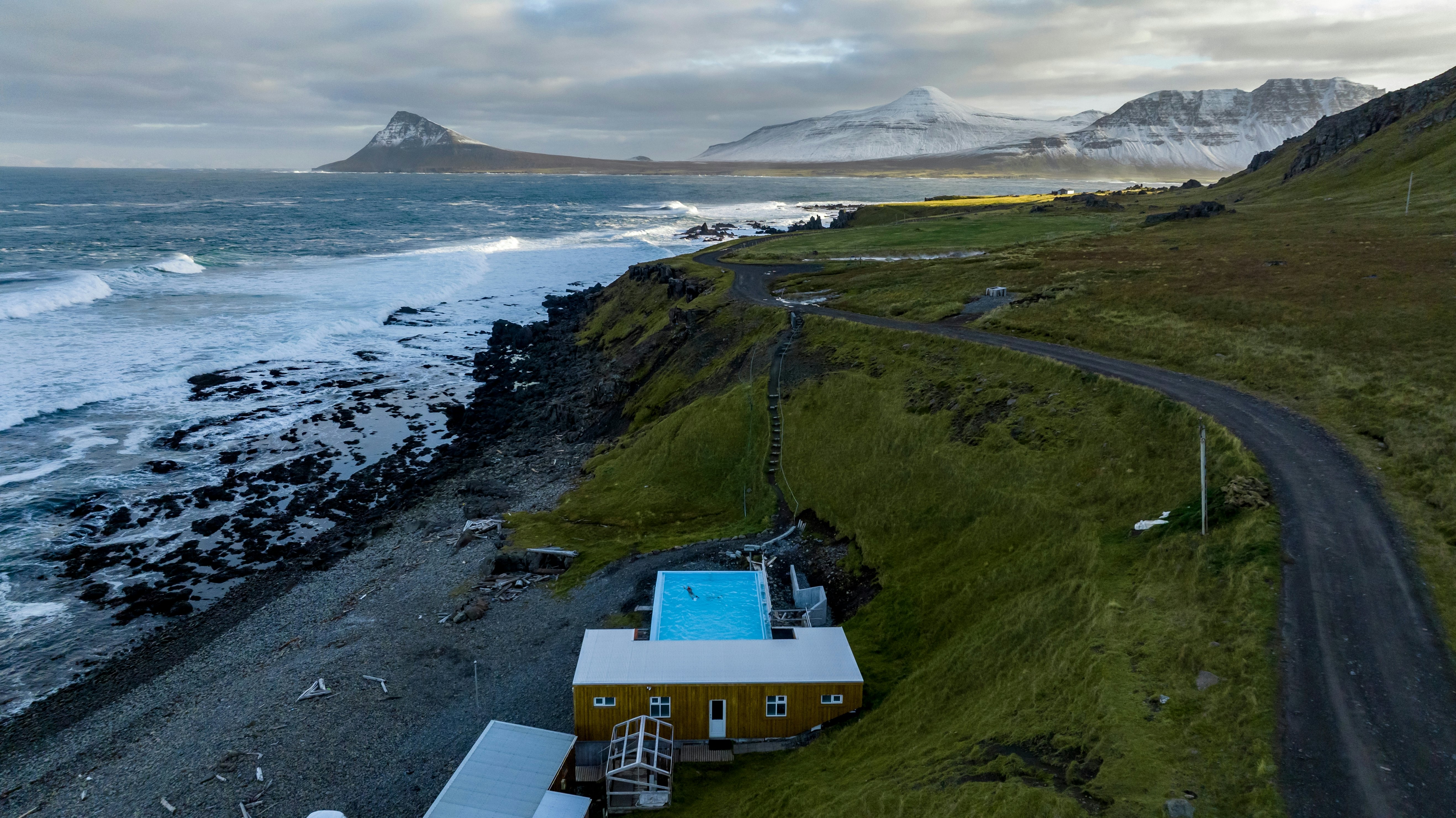 A swimmer swims in Krossneslaug geothermal pool.