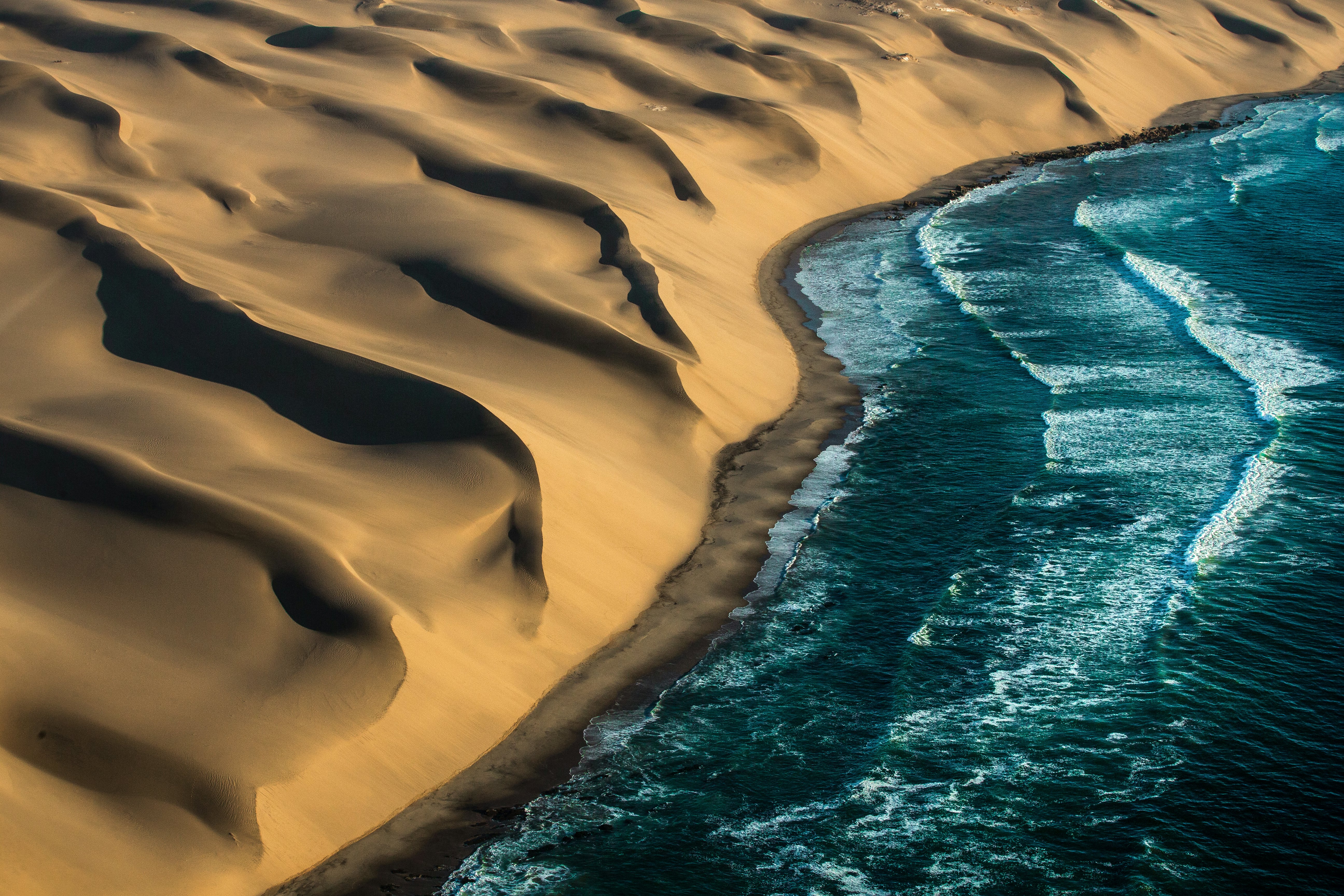 Views of dunes hitting the ocean on the Skeleton Coast, Namibia.