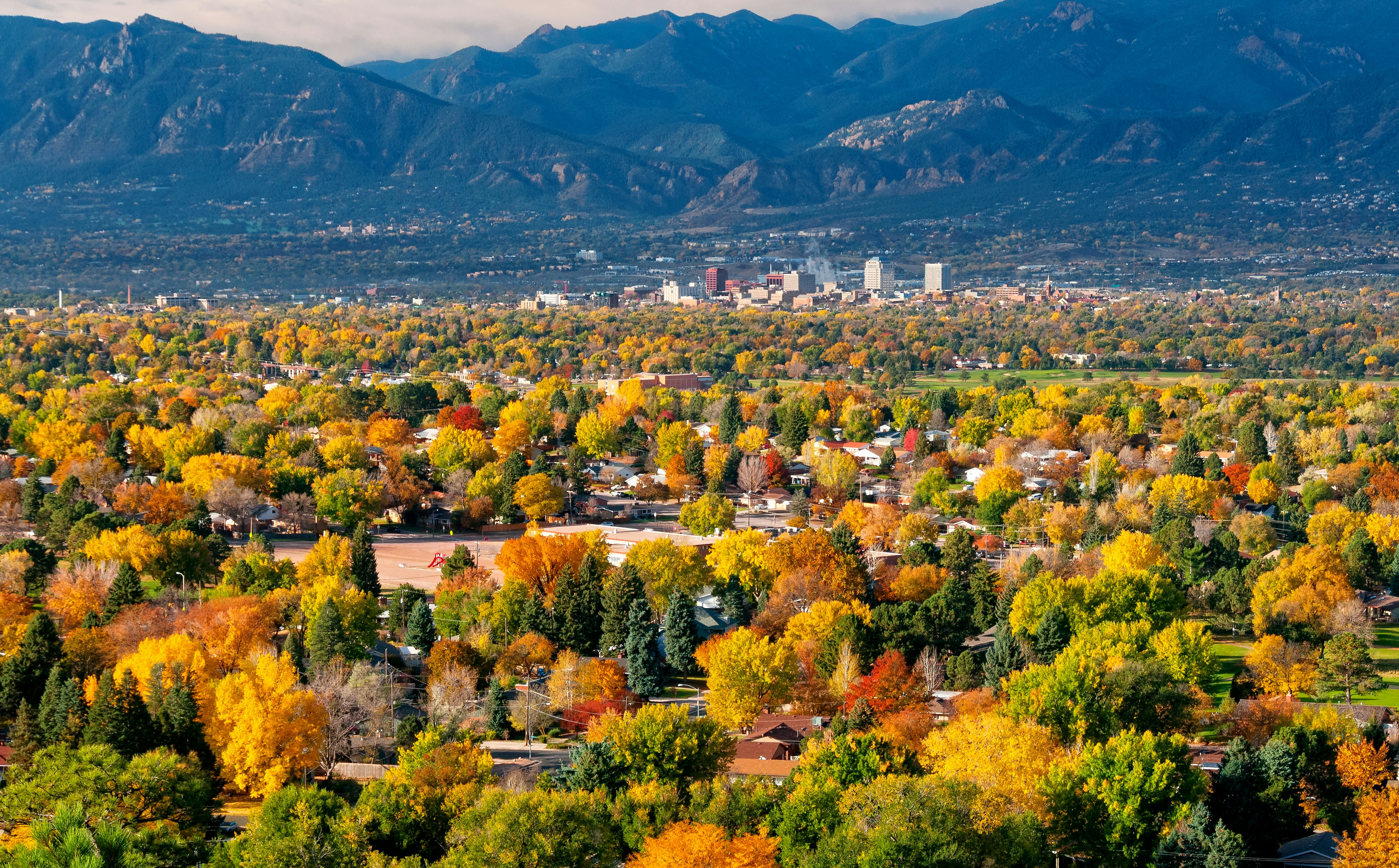 Downtown Colorado Springs with fall foliage and mountains in the distance as seen from Grandview Lookout in Palmer Park, Colorado, USA