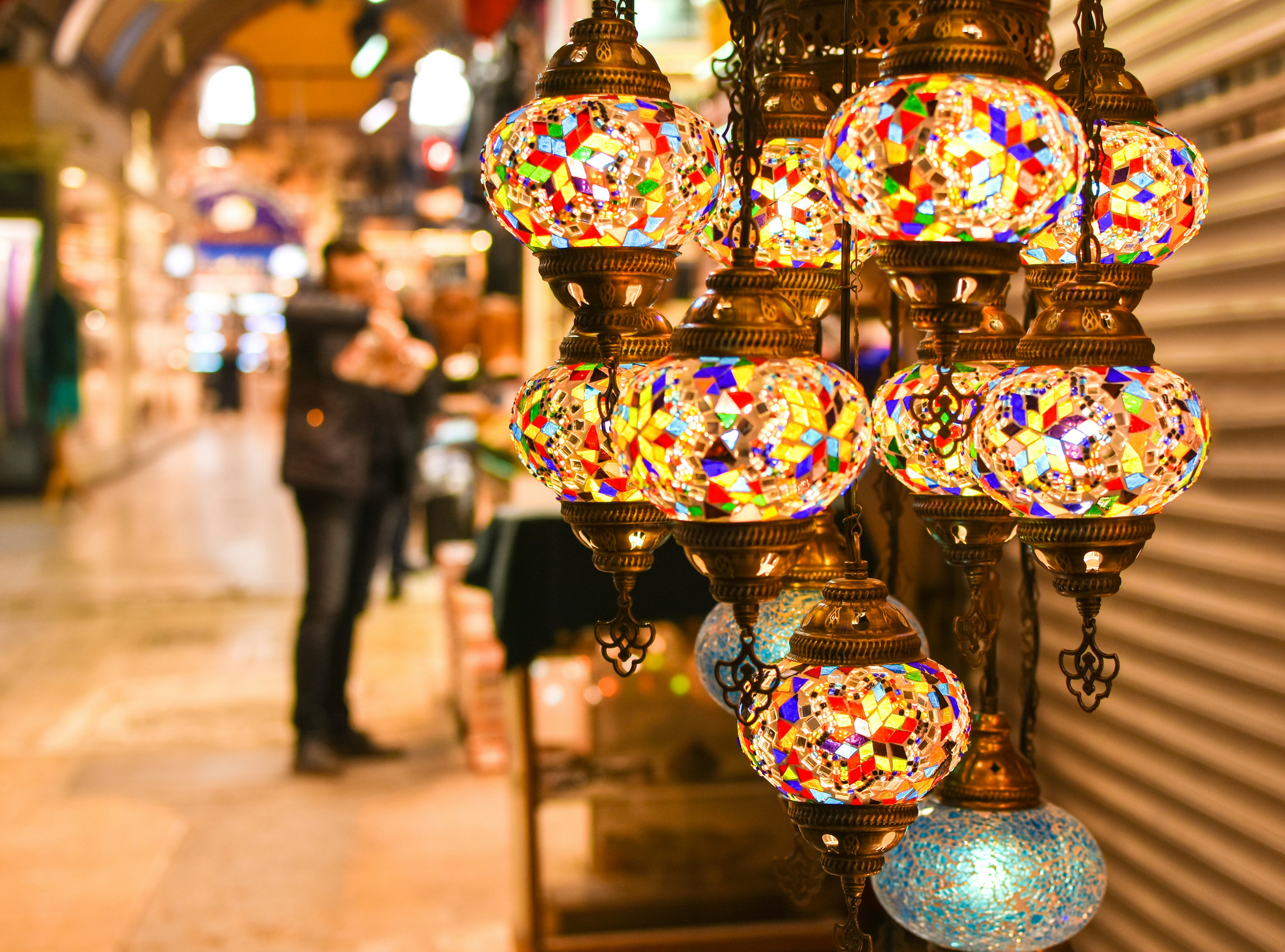 Colorful Turkish lanterns hang outside a store within a covered market