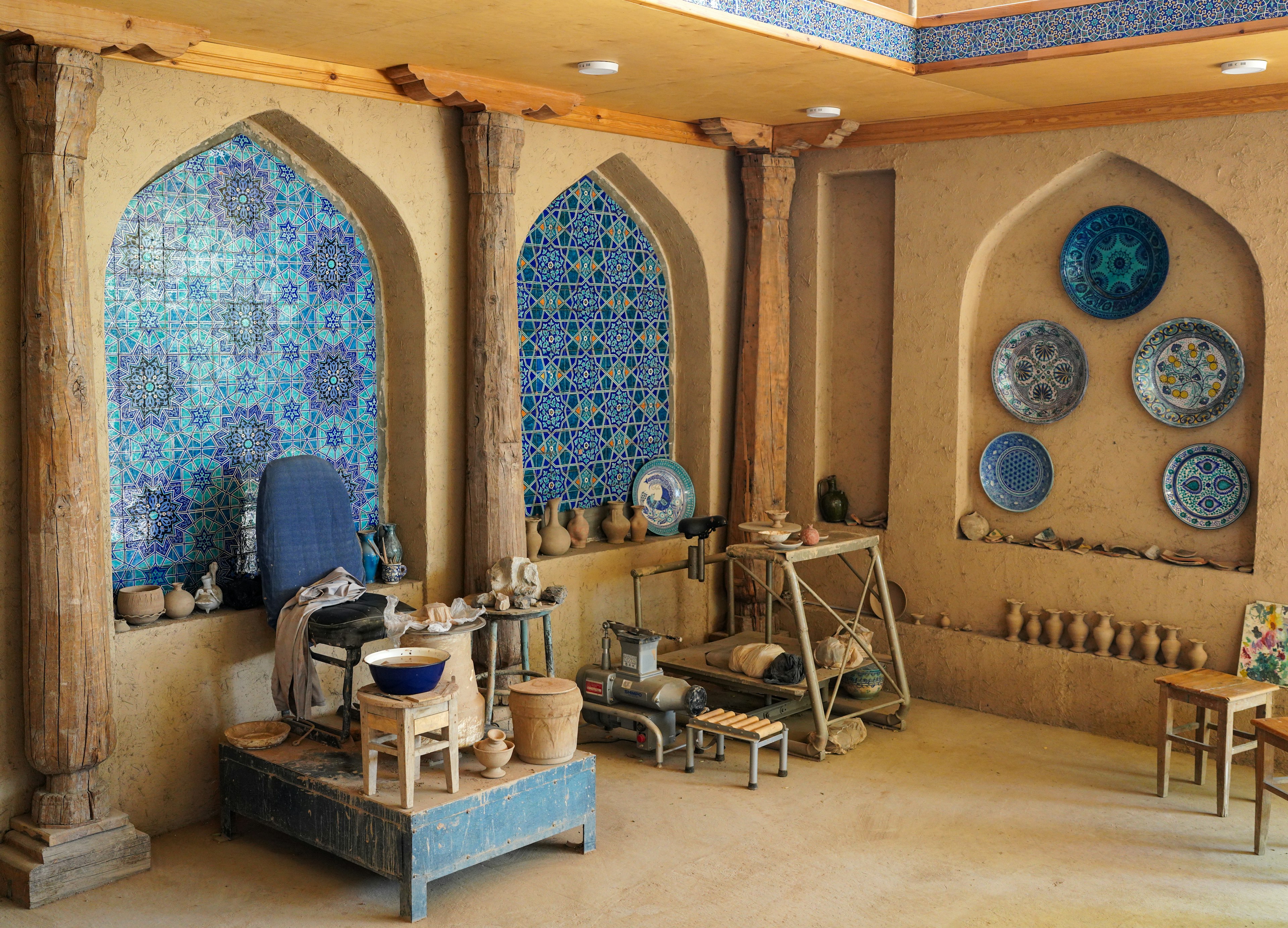 A ceramics workshop decorated with blue tiles and plates mounted on the walls