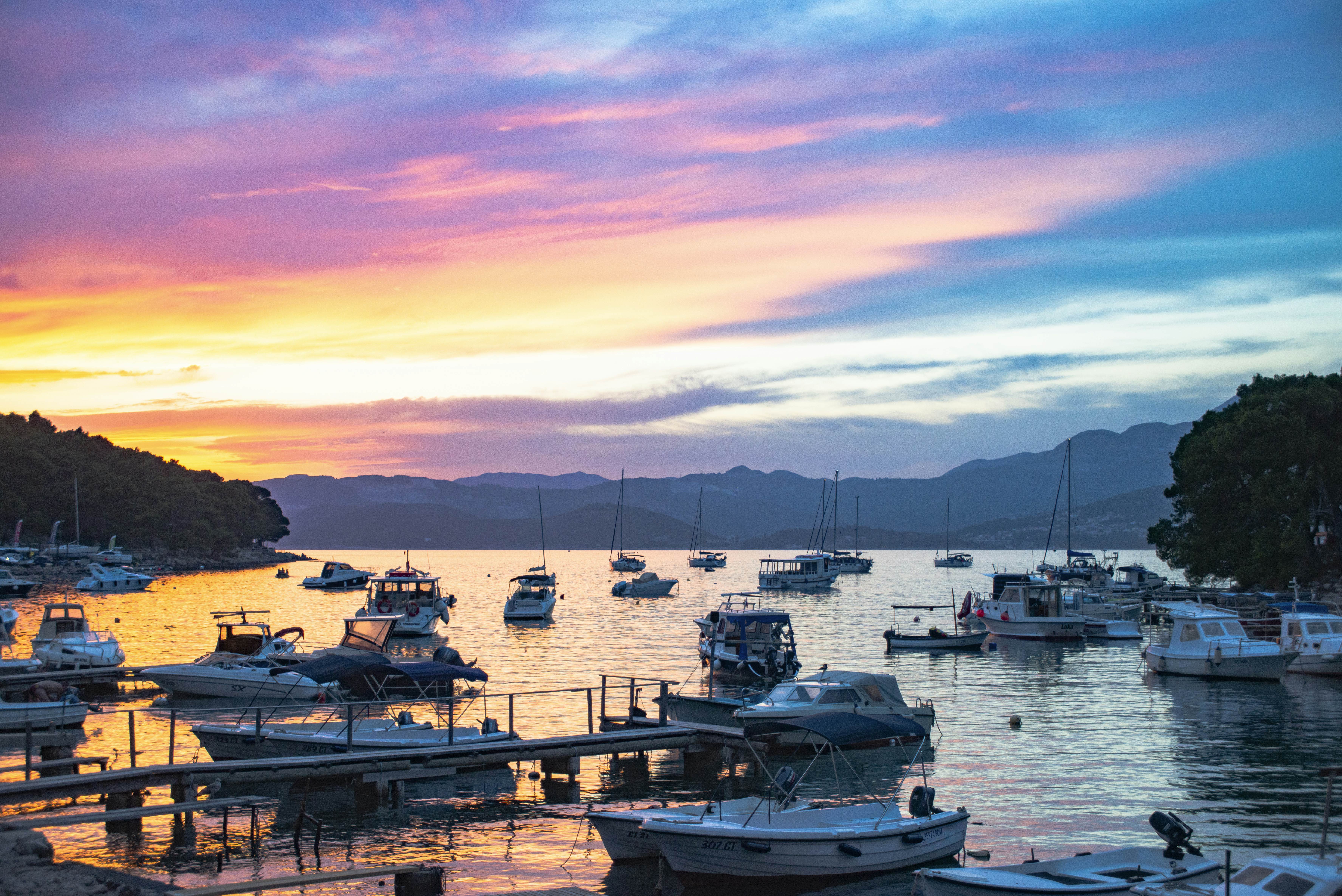 Sunset over a bay where lots of small boats are moored