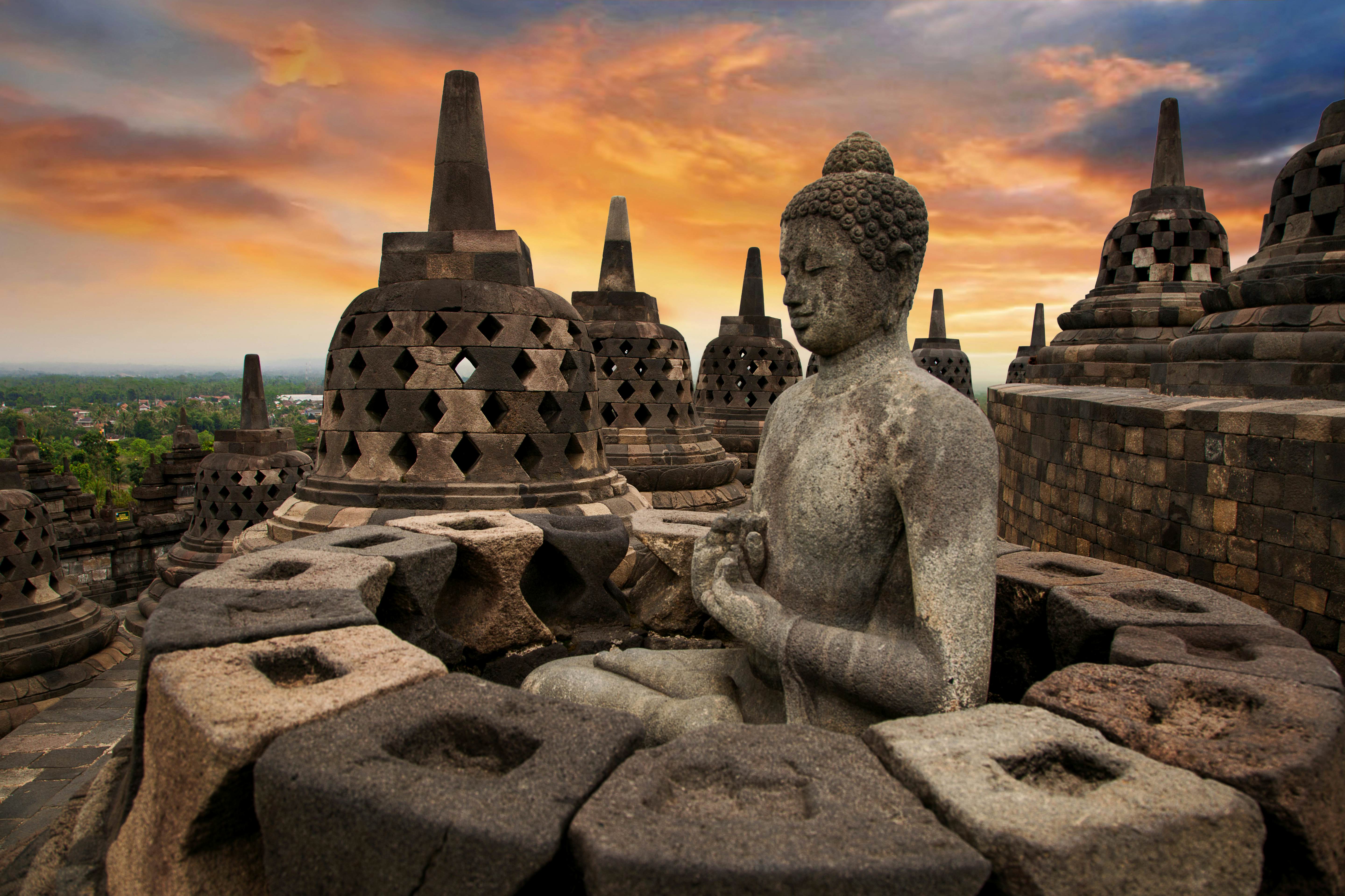 Borobudur, or Barabudur, is a 9th-century Mahayana Buddhist Temple in Magelang, Central Java, Indonesia.  This temple is the world's largest Buddhist temple and also one of the greatest Buddhist monuments in the world. The monument consists of 9 stacked platforms, 6 square and 3 circular, topped by a central dome. The temple is decorated with 2,672 relief panels and 504 Buddha statues. The central dome is surrounded by 72 Buddha statues, each seated inside a perforated stupa.