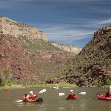 North America, United States, Colorado, Dinosaur National Monument, Green River, children in kayaks near whitewater raft in canyon. MR, PR