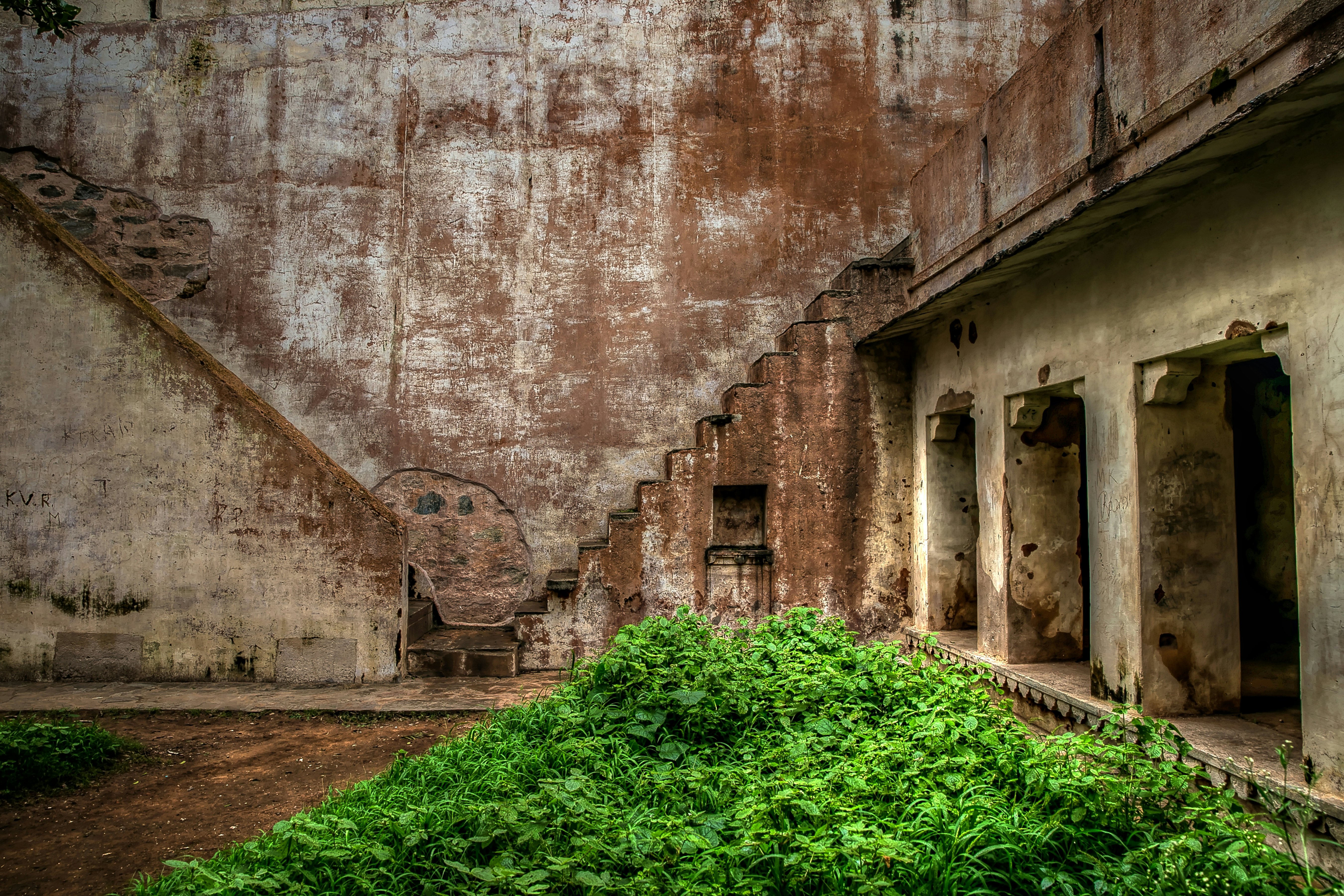 Two sets of steps descend to an area of greenery