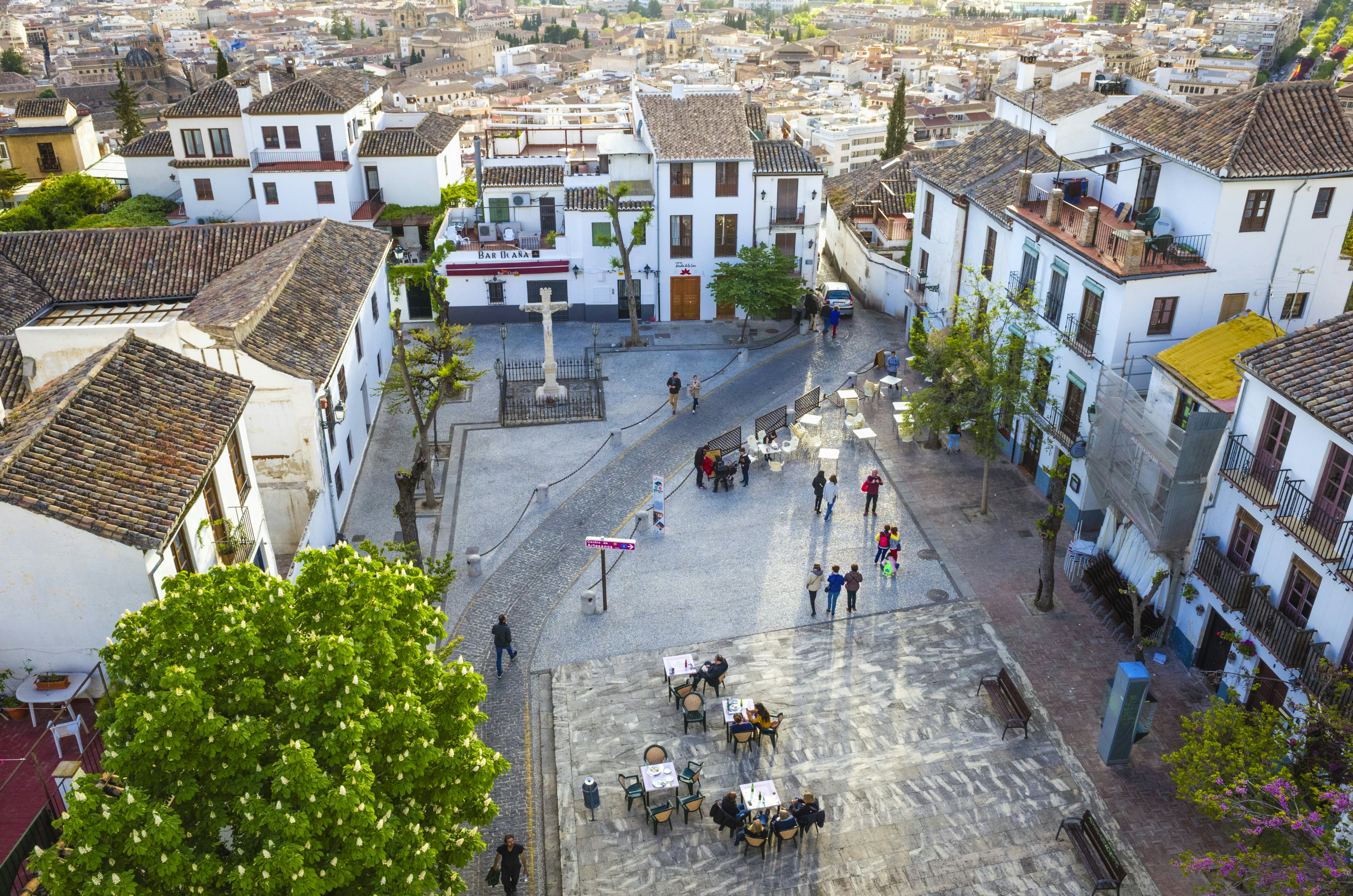 Overhead of the San Miguel Bajo square with people at outdoors cafes in the UNESCO-listed Albaicín district