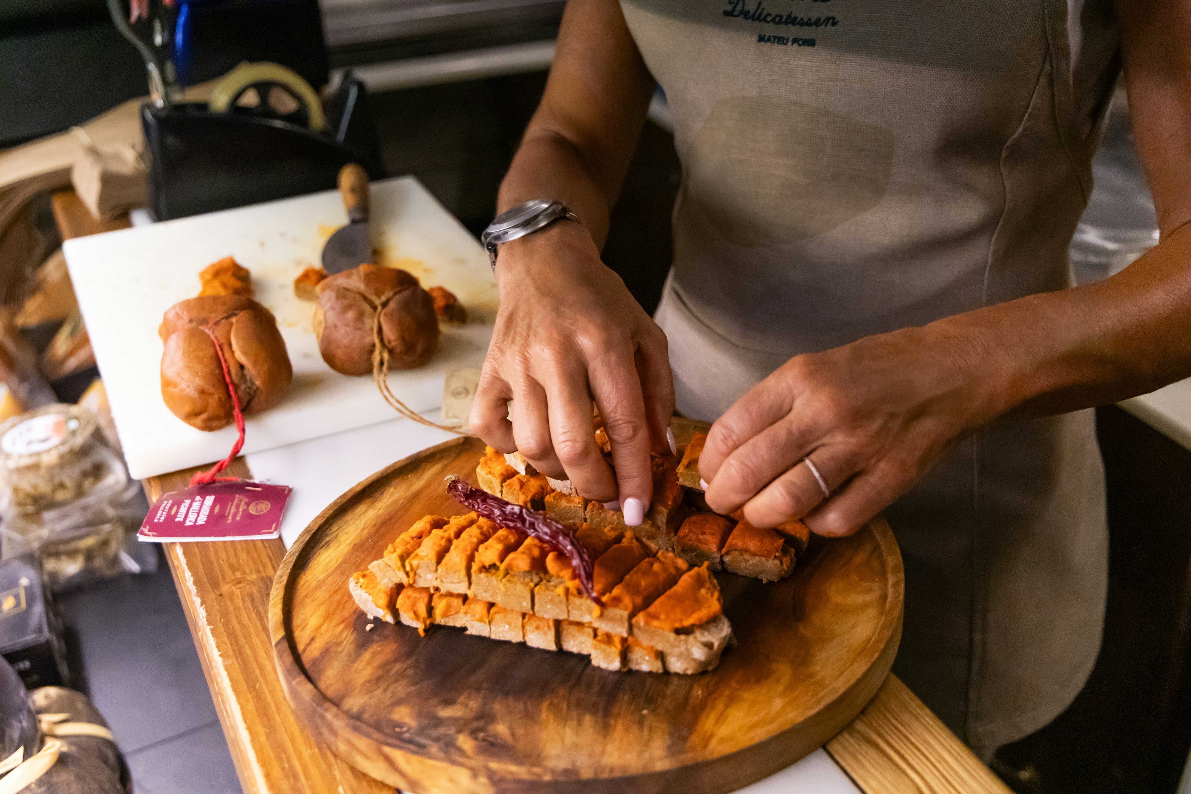 A vendor prepares slices of sobrasada, a traditional Mallorcan cured sausage, at a local market in Palma de Mallorca. 
BIT 2025