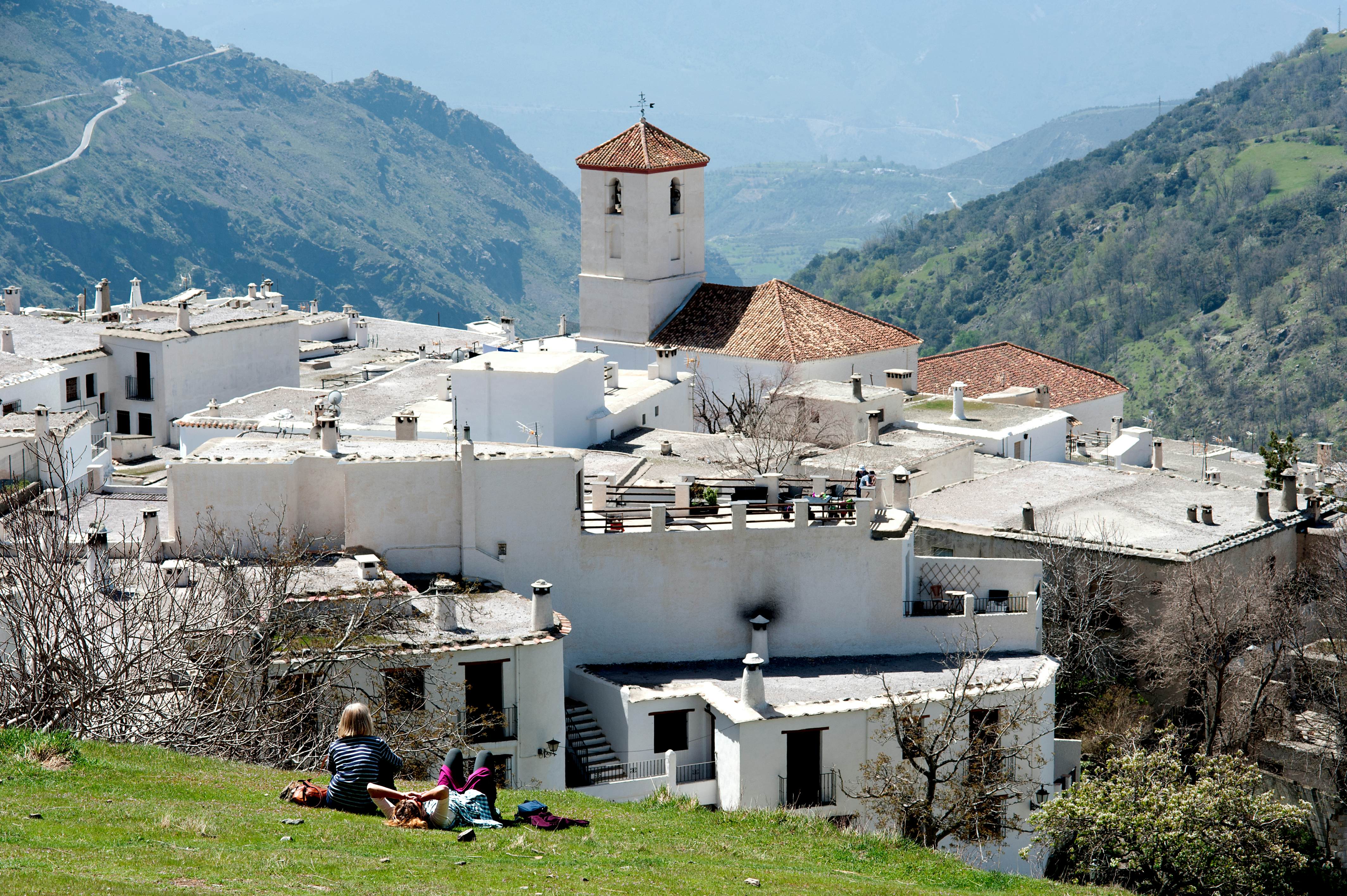 Capileira, Andalucia, Spain, May 2018. Tourist enjoying the sun and the panoramic view of the Alpujarran village of Capileira high up in the Sierra Nevada mountains in Spain's Andalucian region.