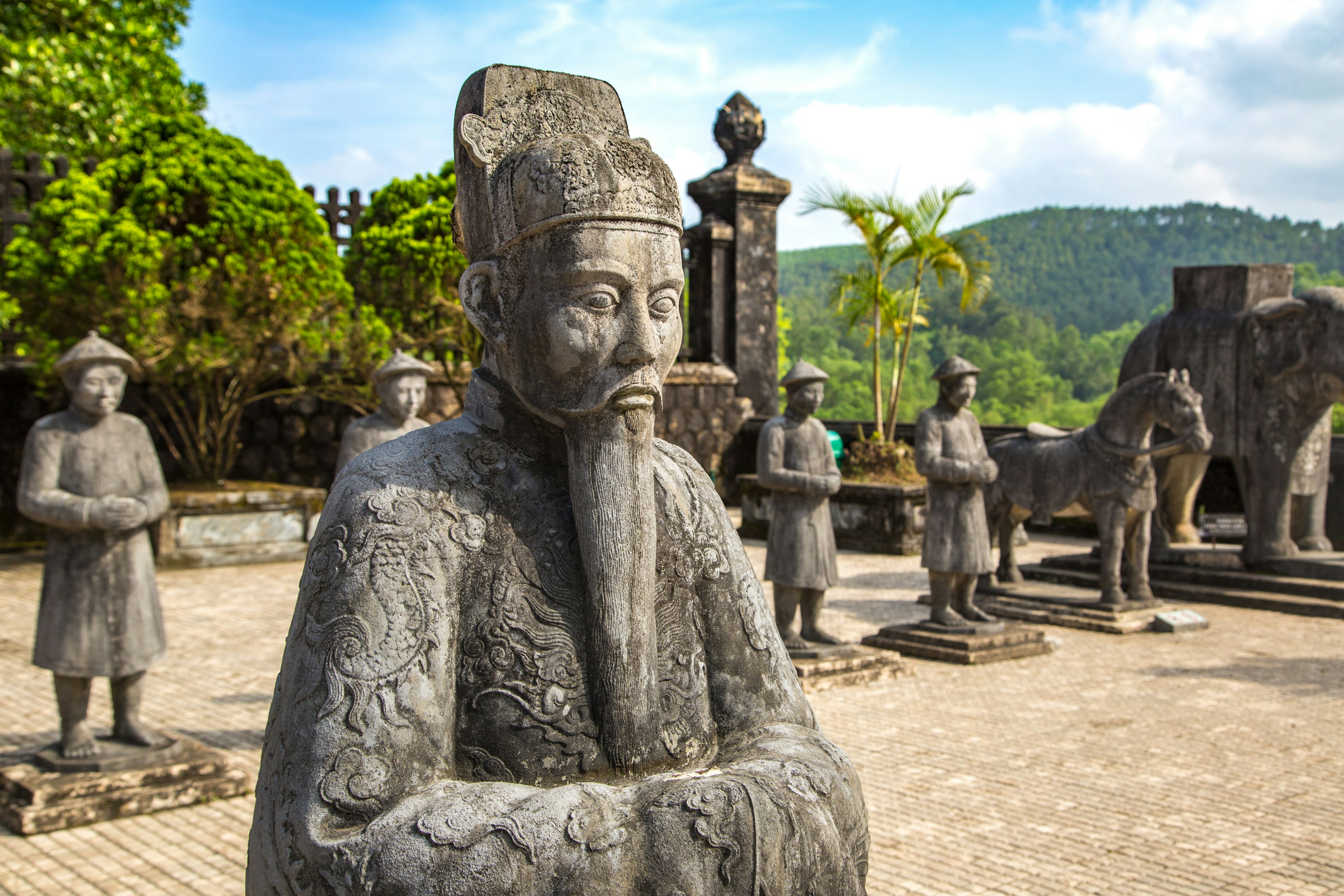 Live-size figurative sculptures depict emperors, members of their court, horses and elephants, displayed in formation in an outdoor plaza at Hue, Vietnam.