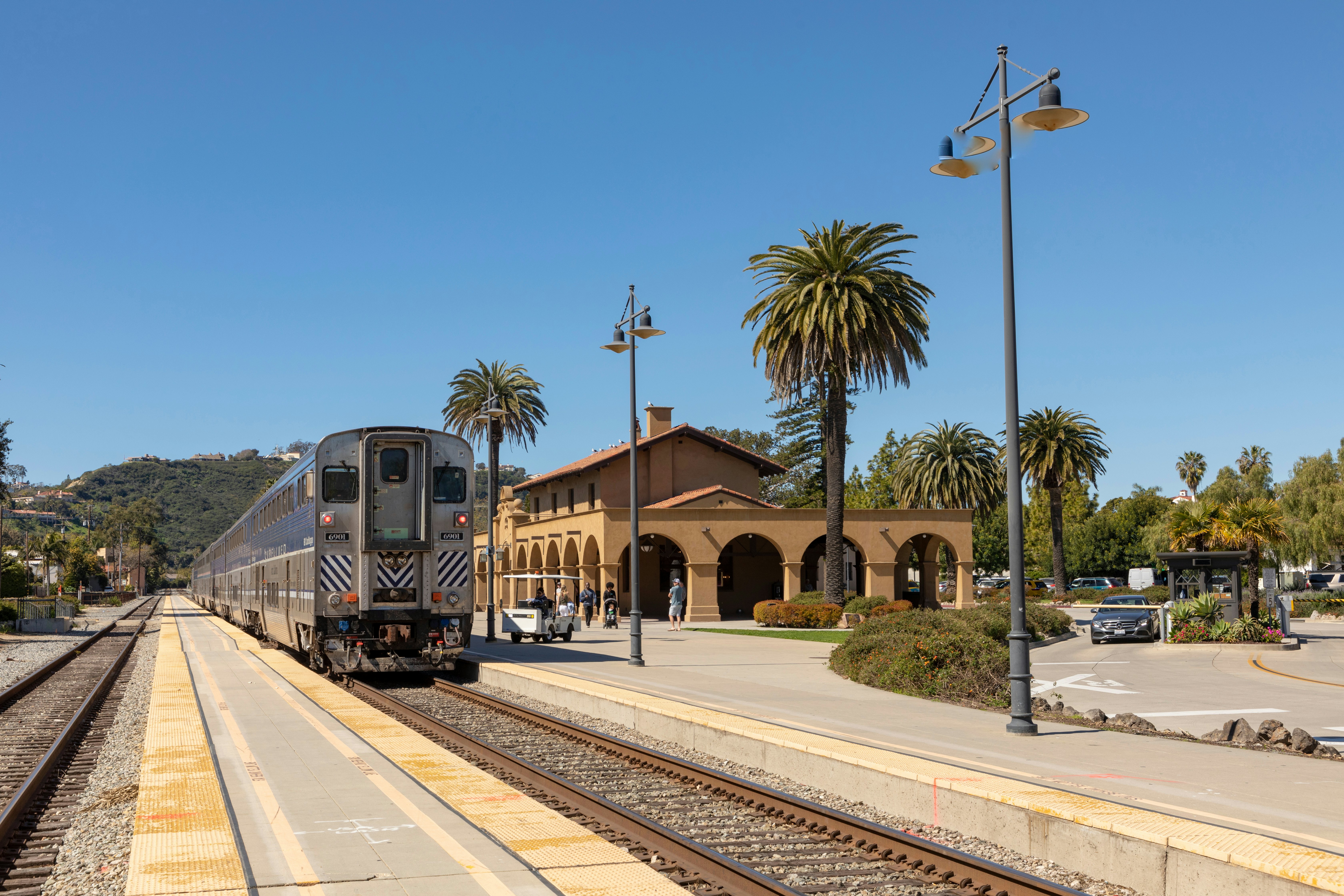 A large train pulls into a station on a sunny day