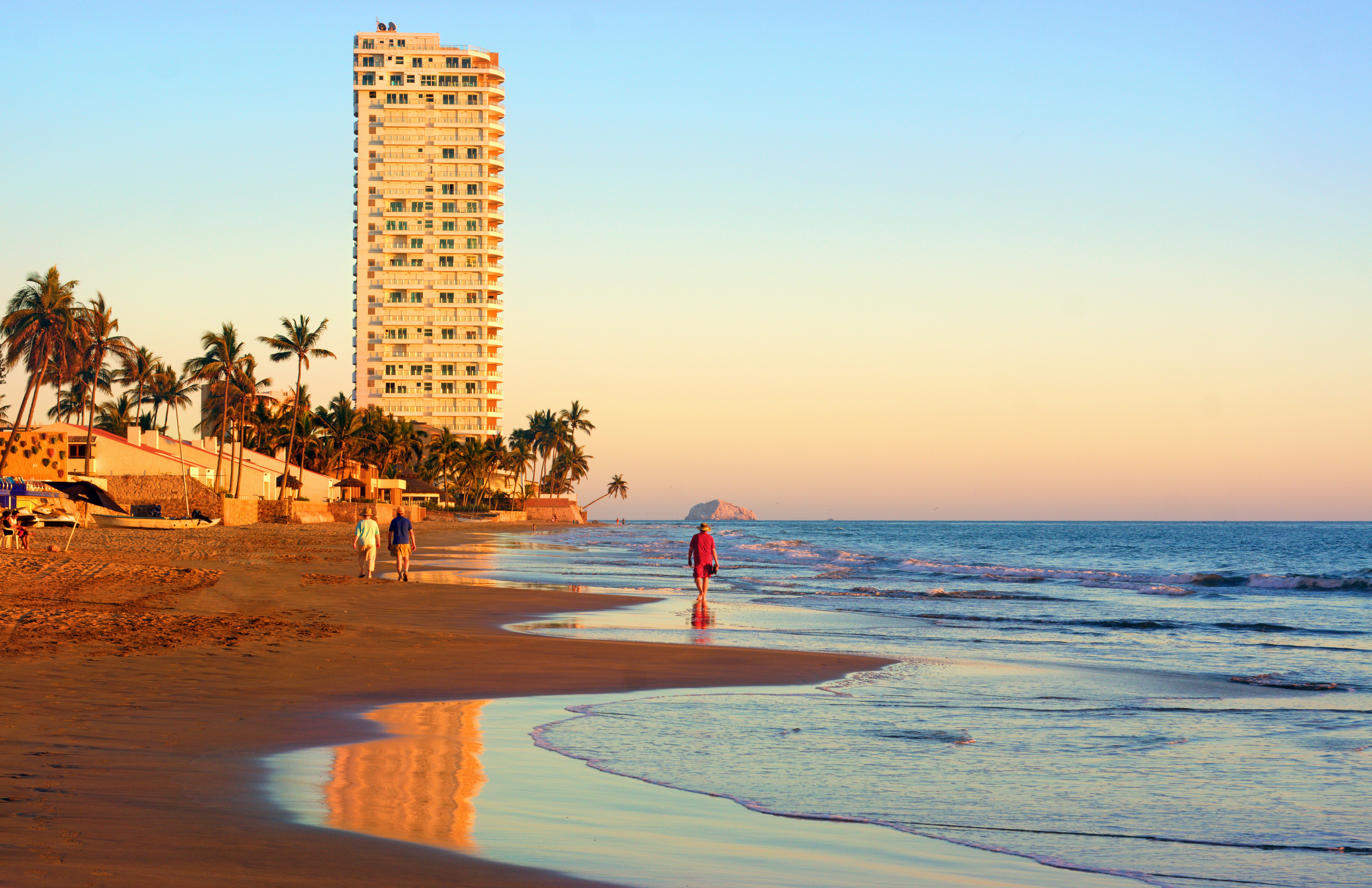 People walk along the beach in Mazatlan