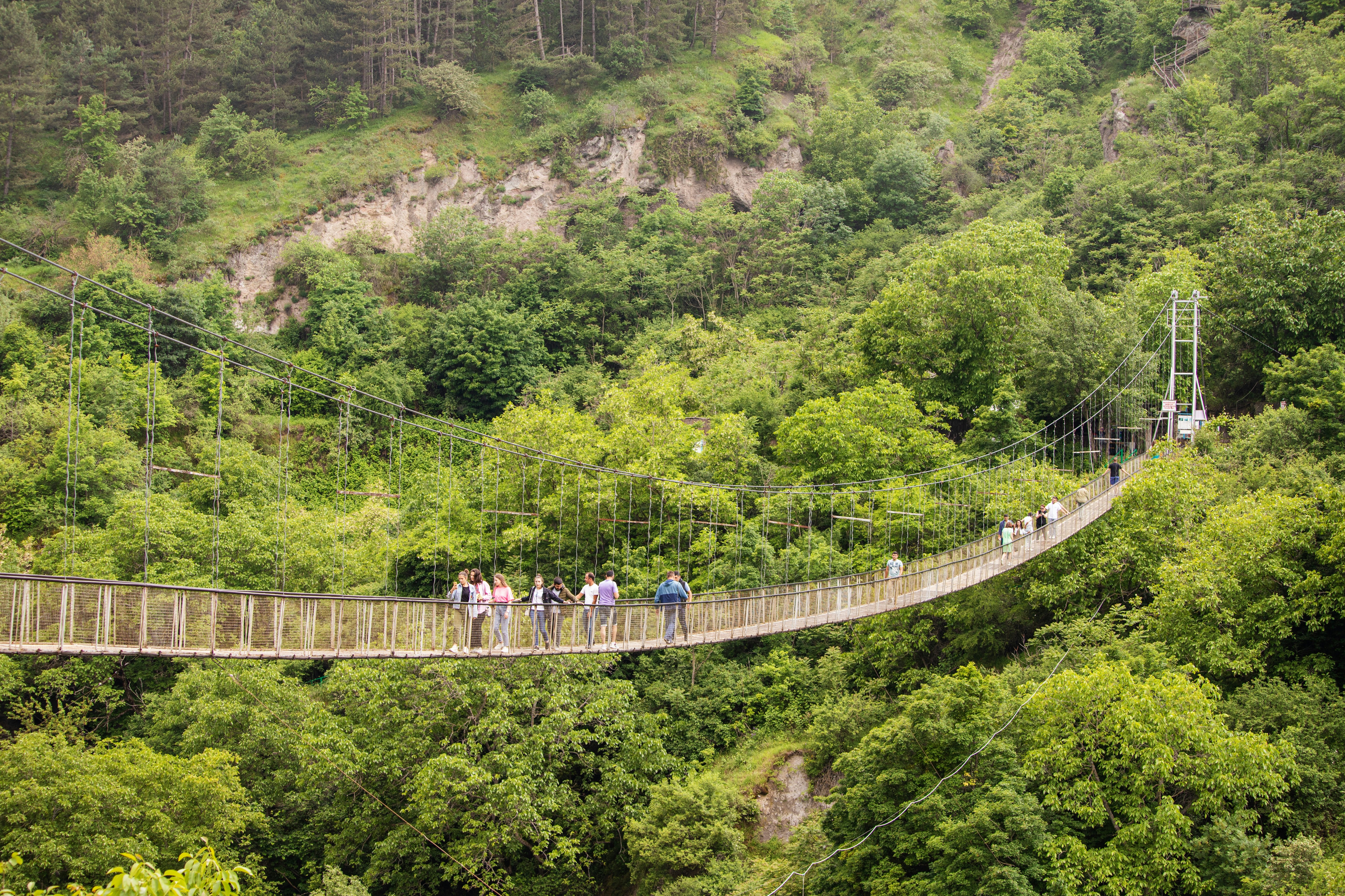 28 May 2021, Khndzoresk, Armenia: Crowd of tourists at the famous suspension bridge in Khndzoresk, Armenia, leading to the ancient cave city.