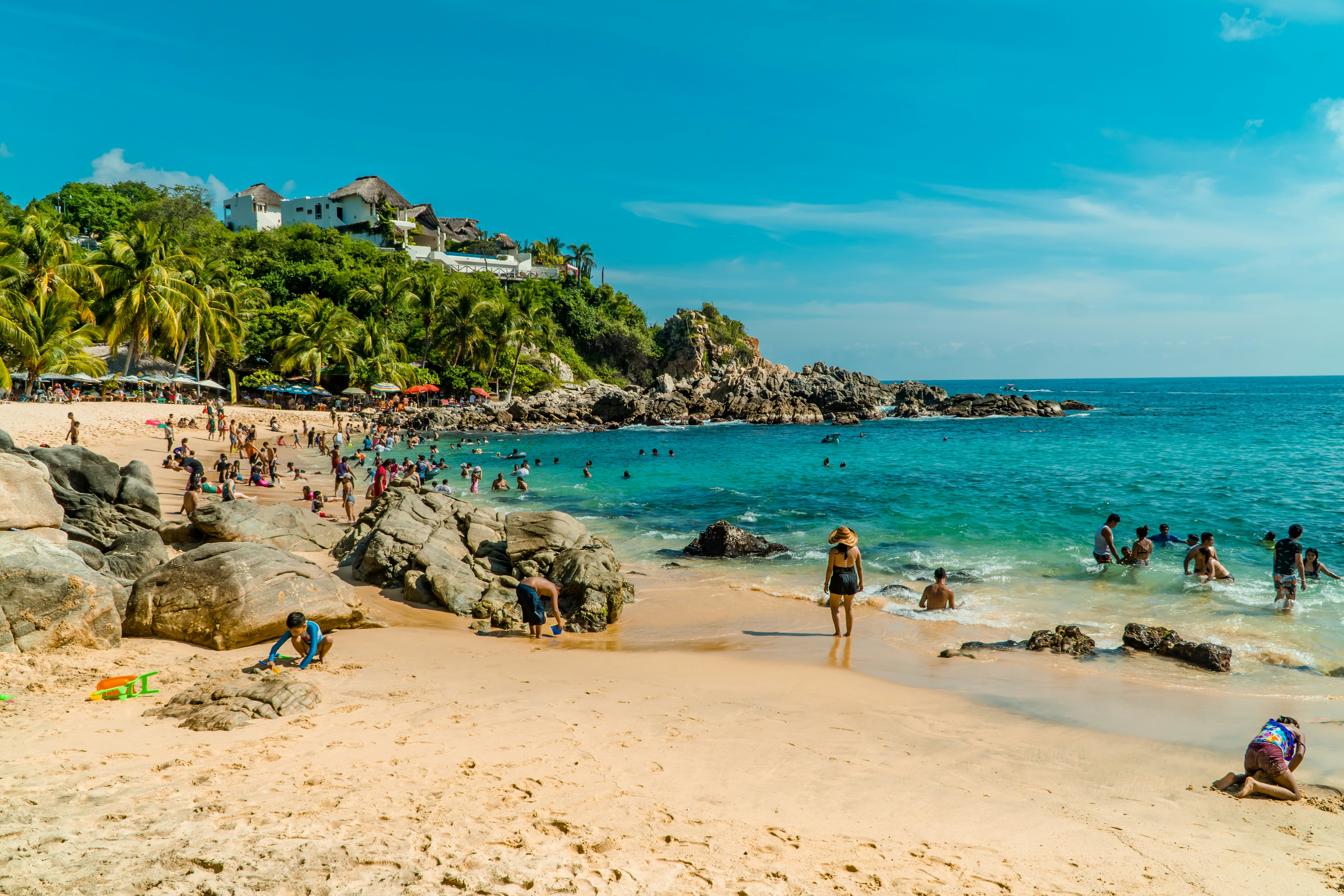 Families swimming and sunbathing in Puerto Escondido, Mexico.