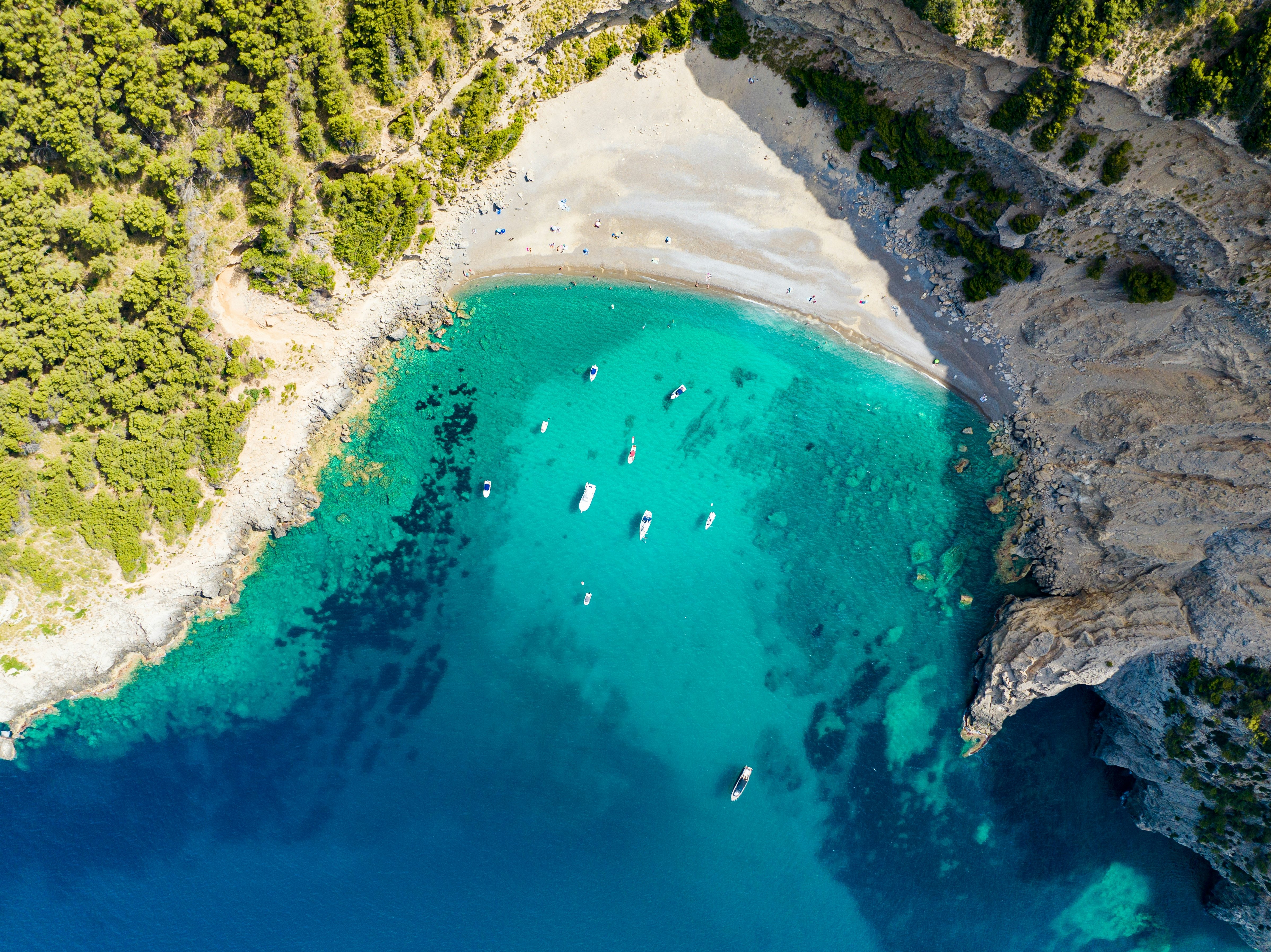 Boats float in the cove at Platja des Coll Baix, Mallorca.