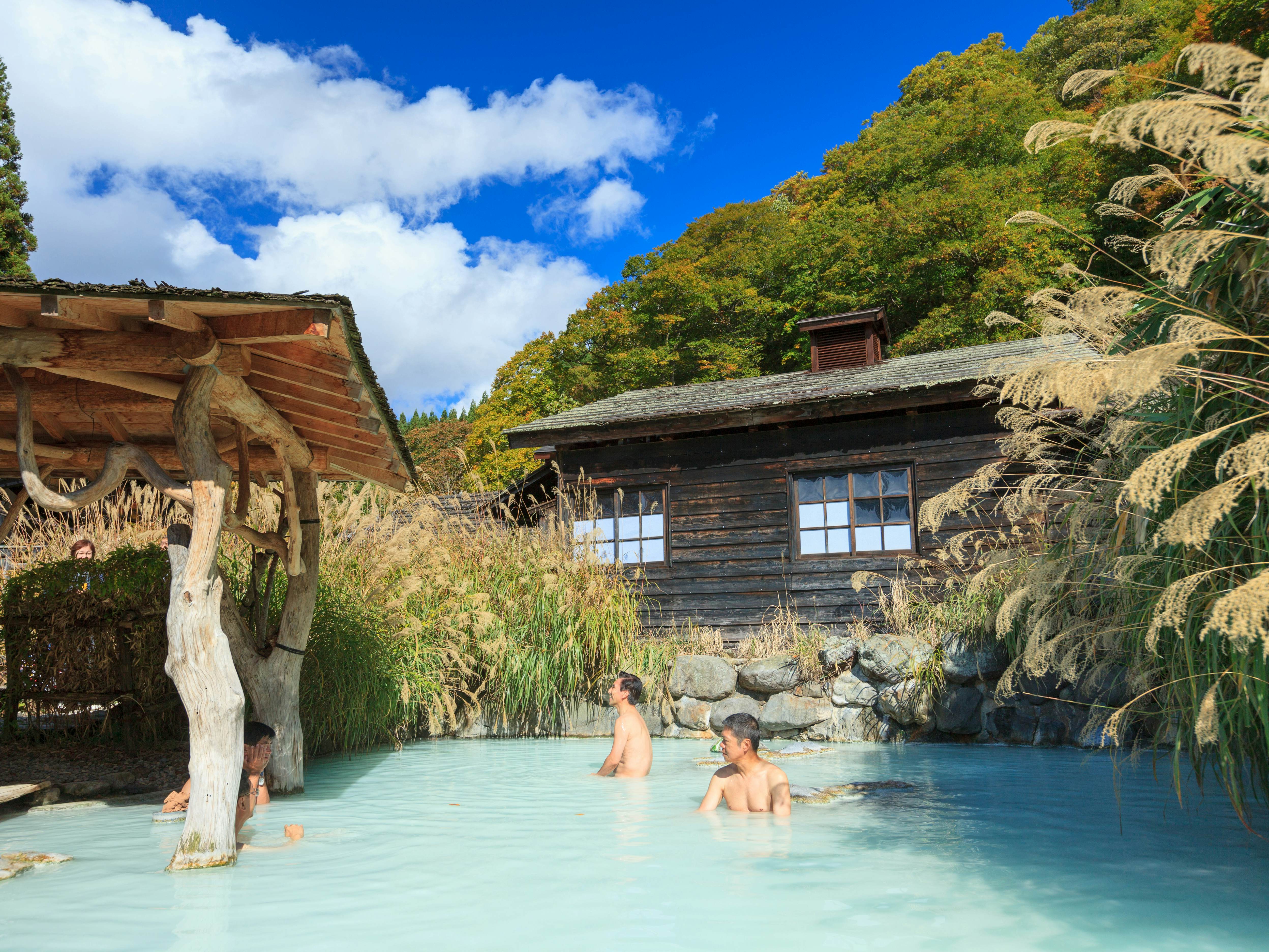 People soaking in outdoor hot spring pool at Tsurunoyu onsen.