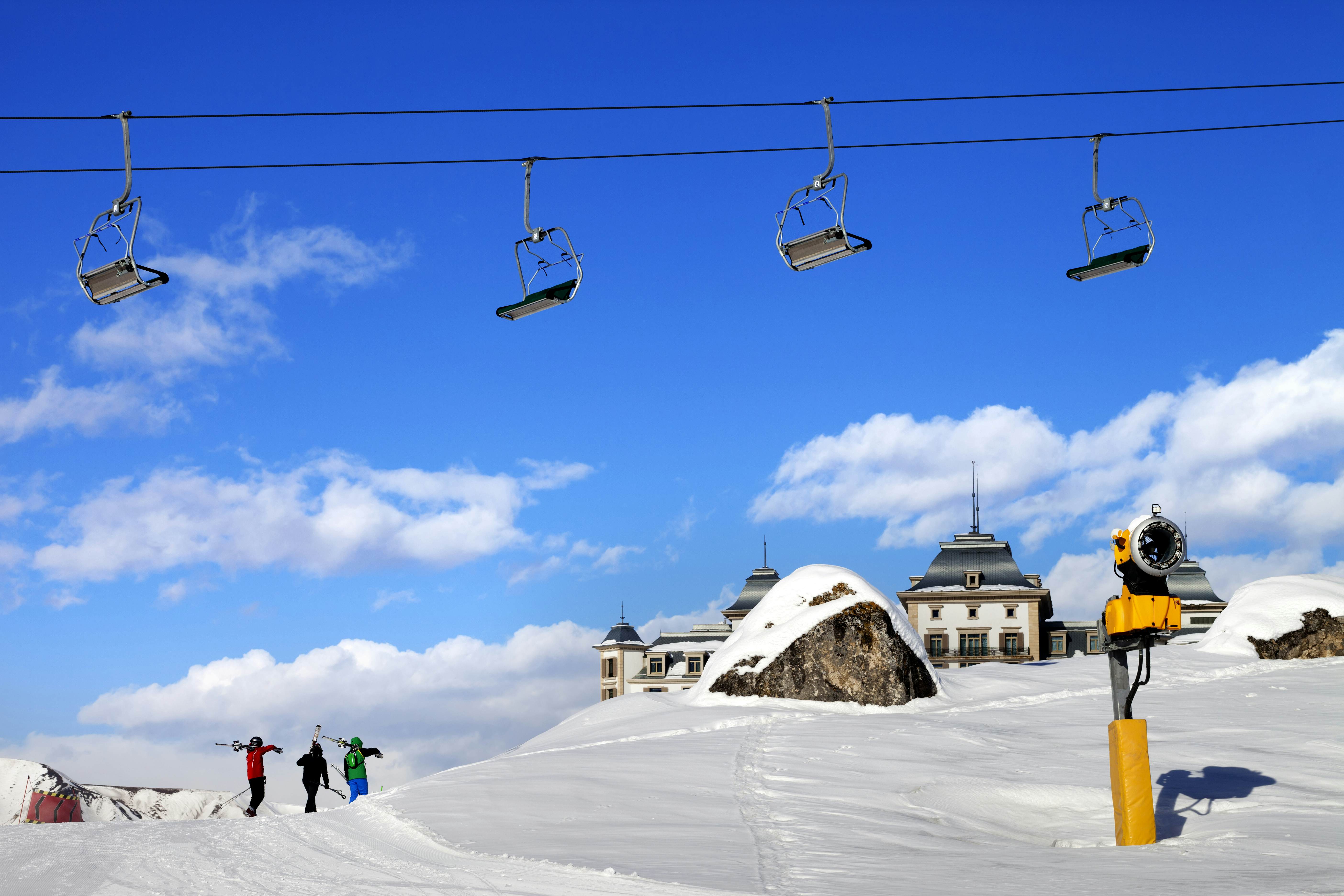 Chair-lift and three skiers on a ski slope at Shahdag, Azerbaijan.