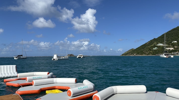 Boats anchored in the ocean near a floating bar