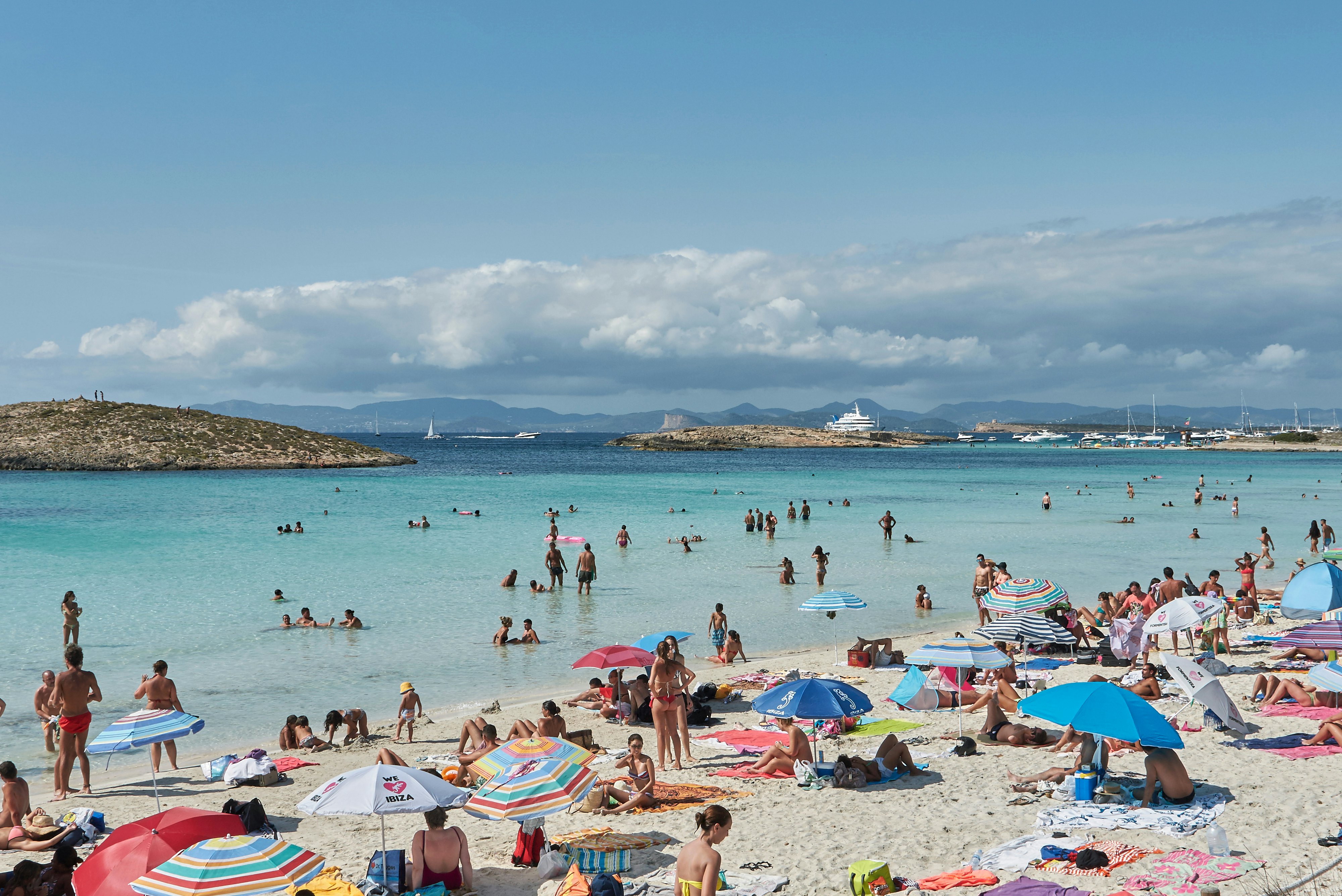 Tourists swimming and sunbathing in Platja Illetes in Formentera.