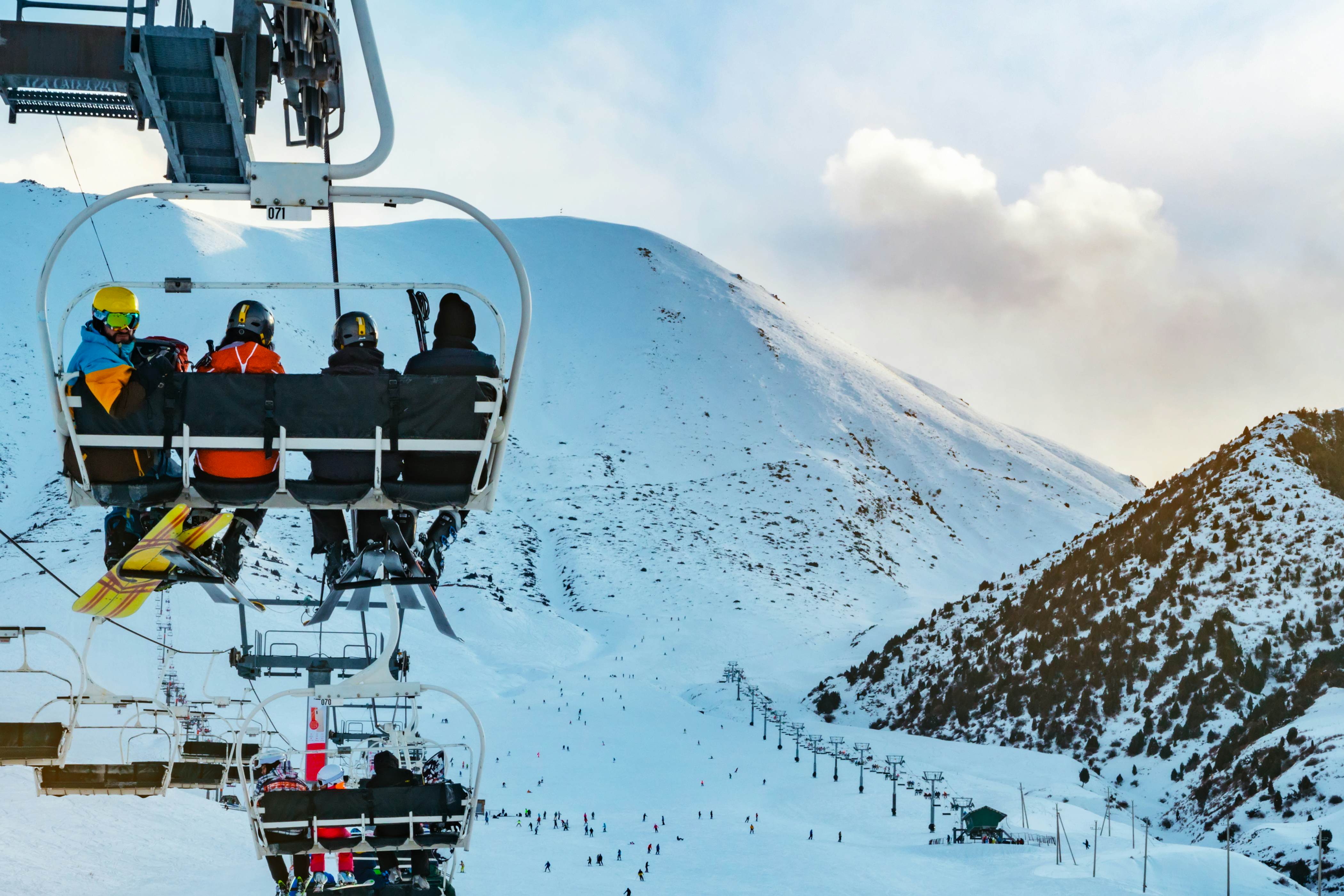 Skiers on a chairlift rides. Skiing in the mountain of Kyrgyzstan. Chunkurchak Ski Resort