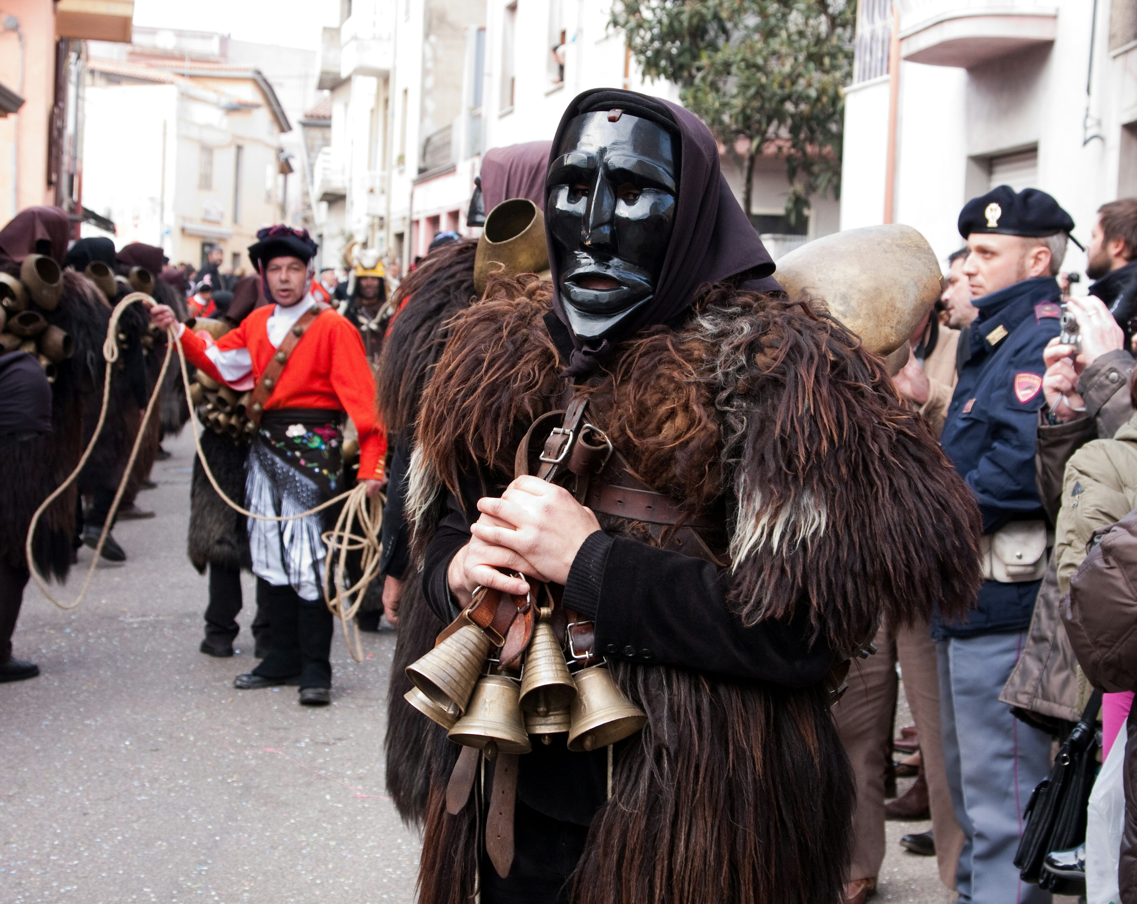 Costumed, masked ”mamuthones,” men clad in hand-carved black masks and shaggy sheepskins, Mamoiada, Sardinia, Italy.