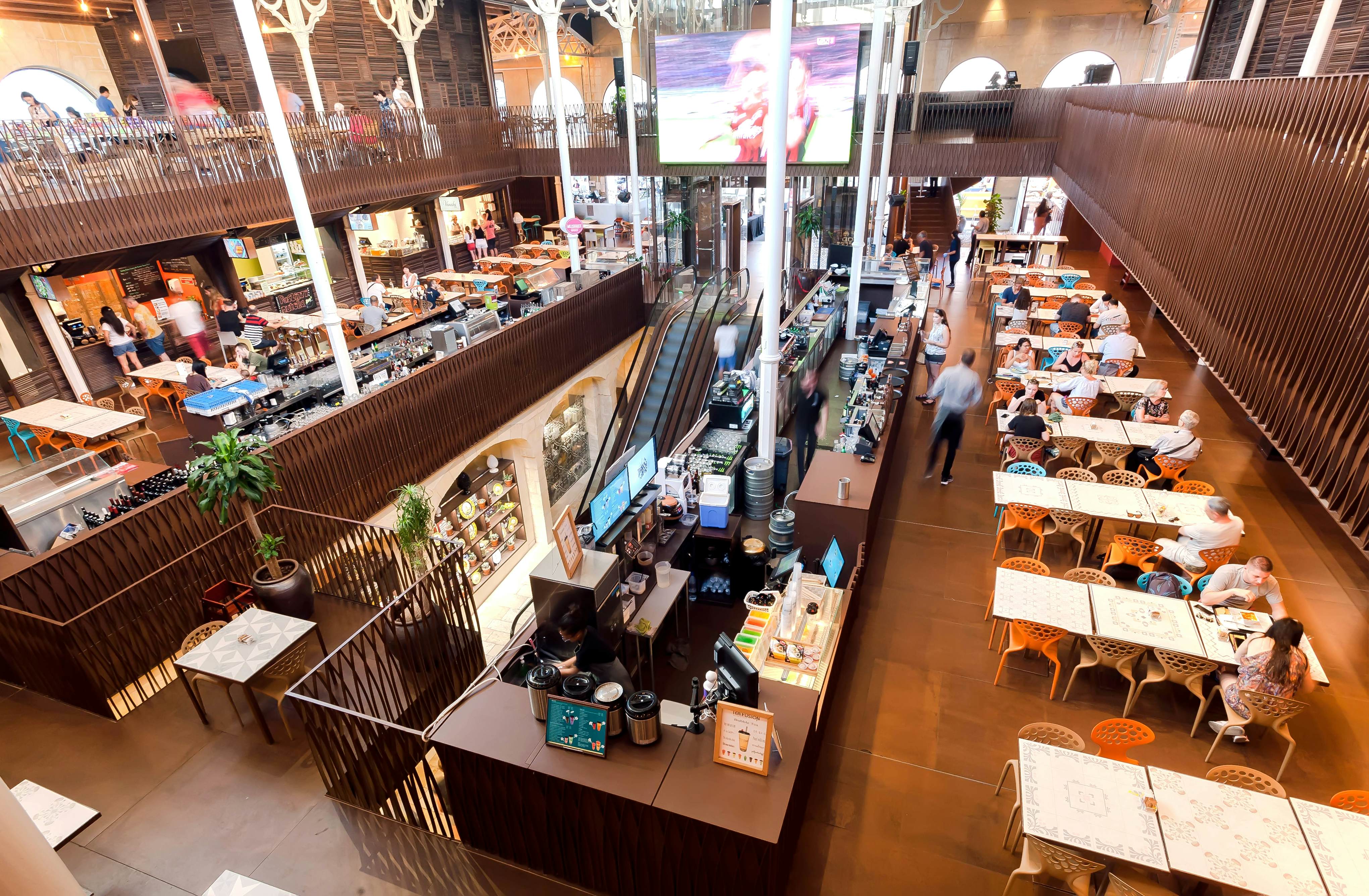 VALLETTA, MALTA: People eating dinner inside covered city market Is-Suq Tal-Belt with different eateries in a communal area on 29 September, 2019. Valletta city is a World Heritage Site by UNESCO, License Type: media, Download Time: 2025-02-06T14:54:46.000Z, User: tasminwaby56, Editorial: true, purchase_order: 65050 - Digital Destinations and Articles, job: Online Editorial, client: Valletta TTD, other: Tasmin Waby