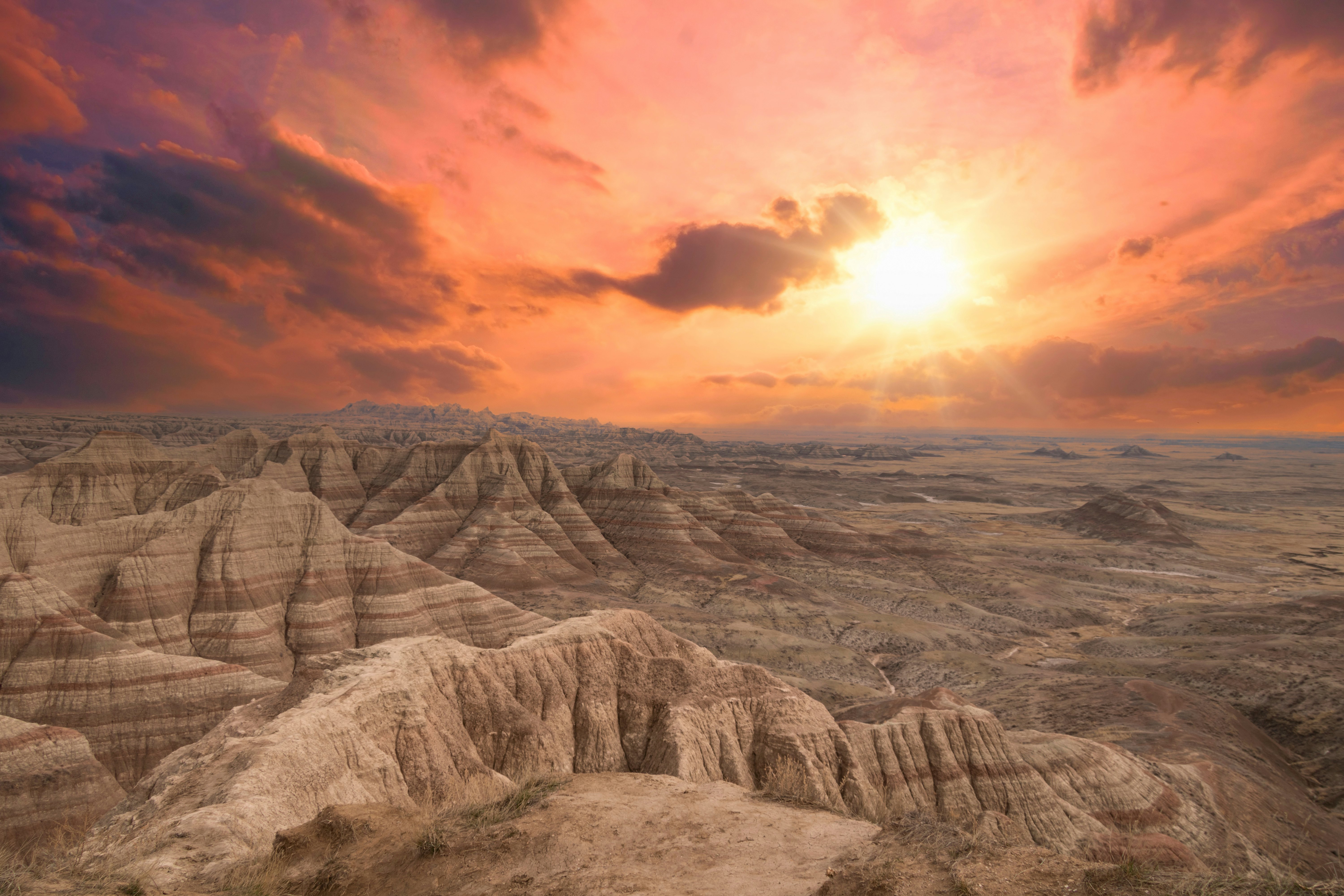 A dramatic and beautiful sunset falls over the painted rocks of Badlands National Park in South Dakota, United States