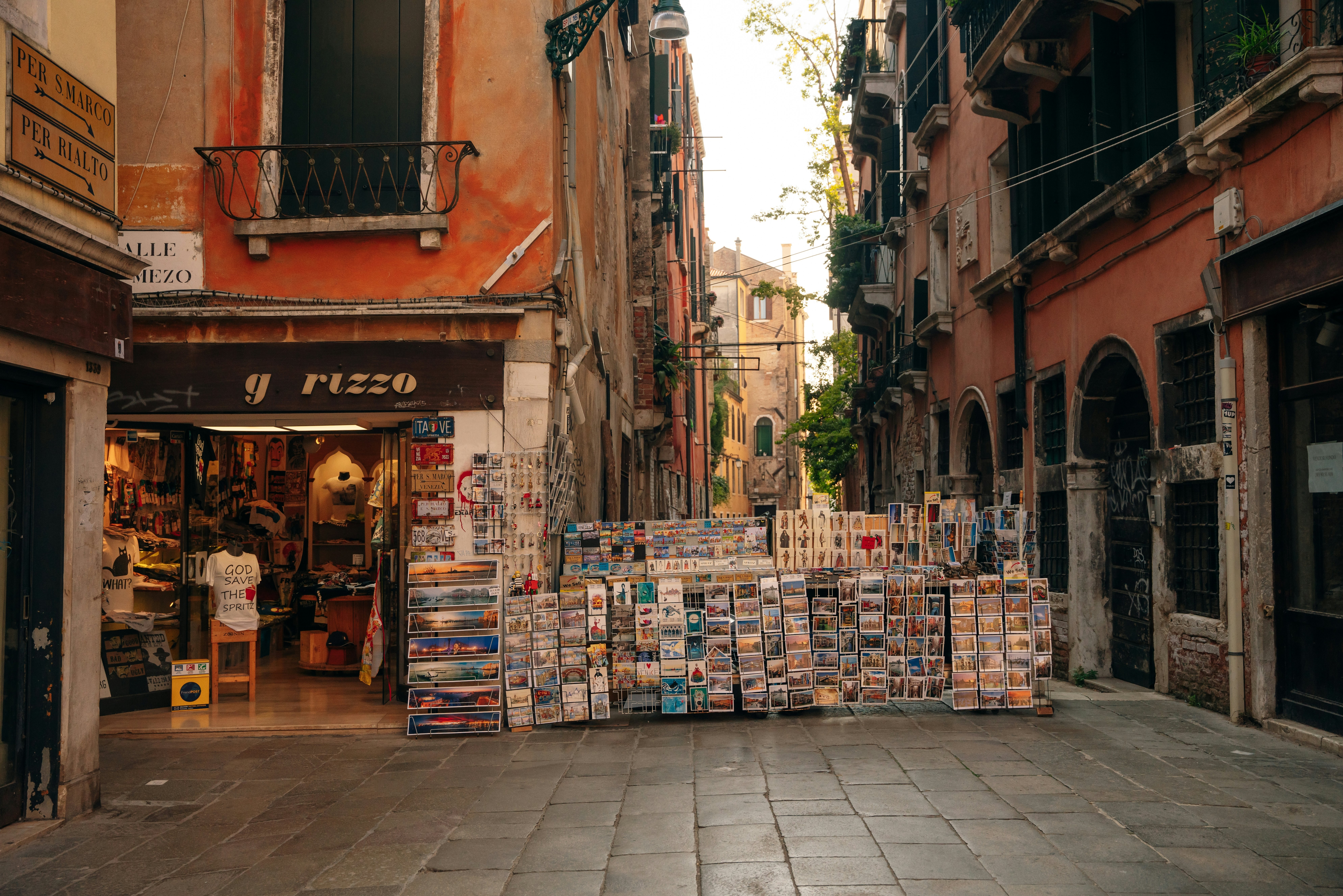 A quaint store in an alleyway selling souvenirs including t-shirts, cards and posters.