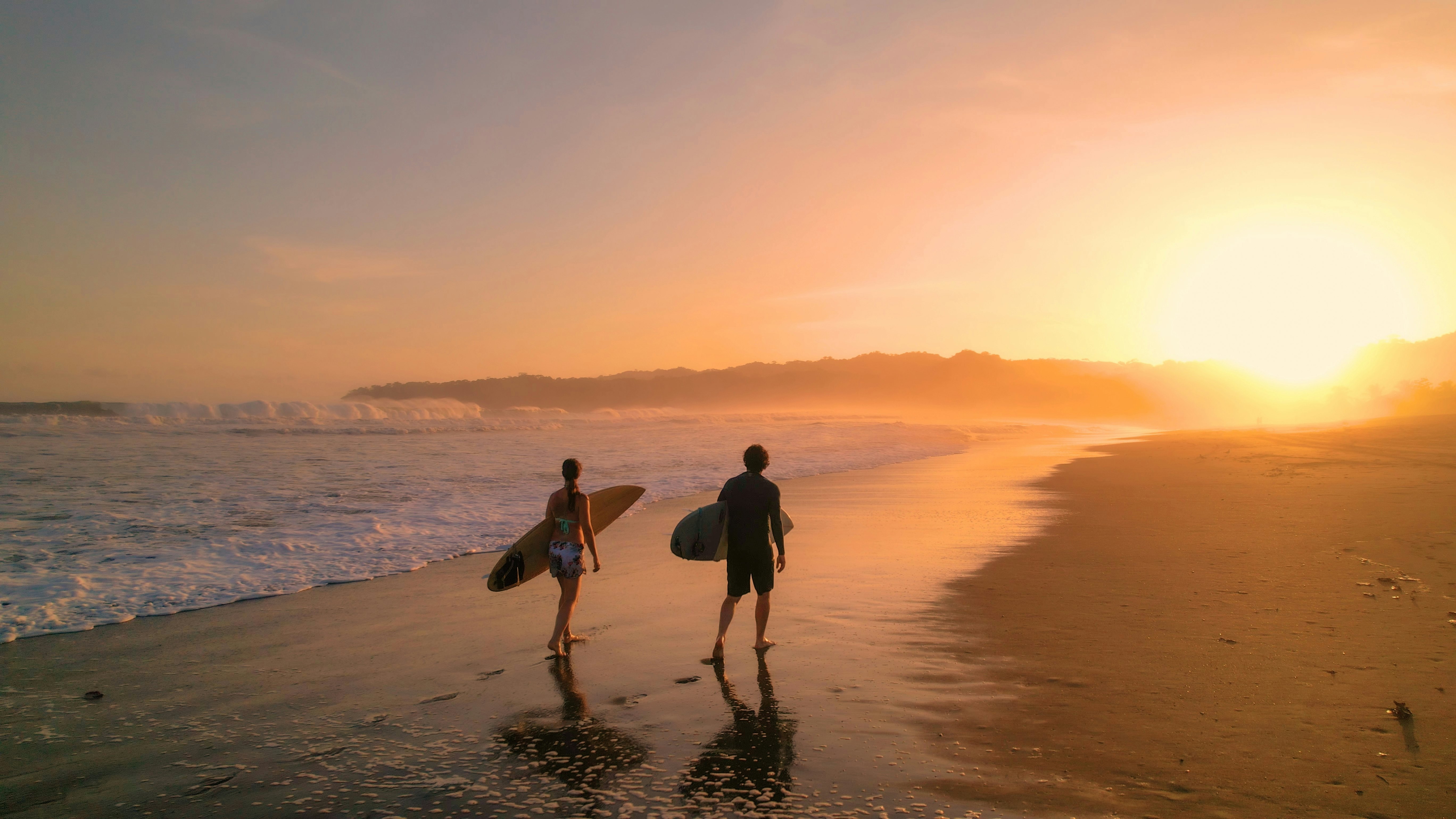 Surfers watch big breaking waves from beach after sunset surf session on Playa Venao.