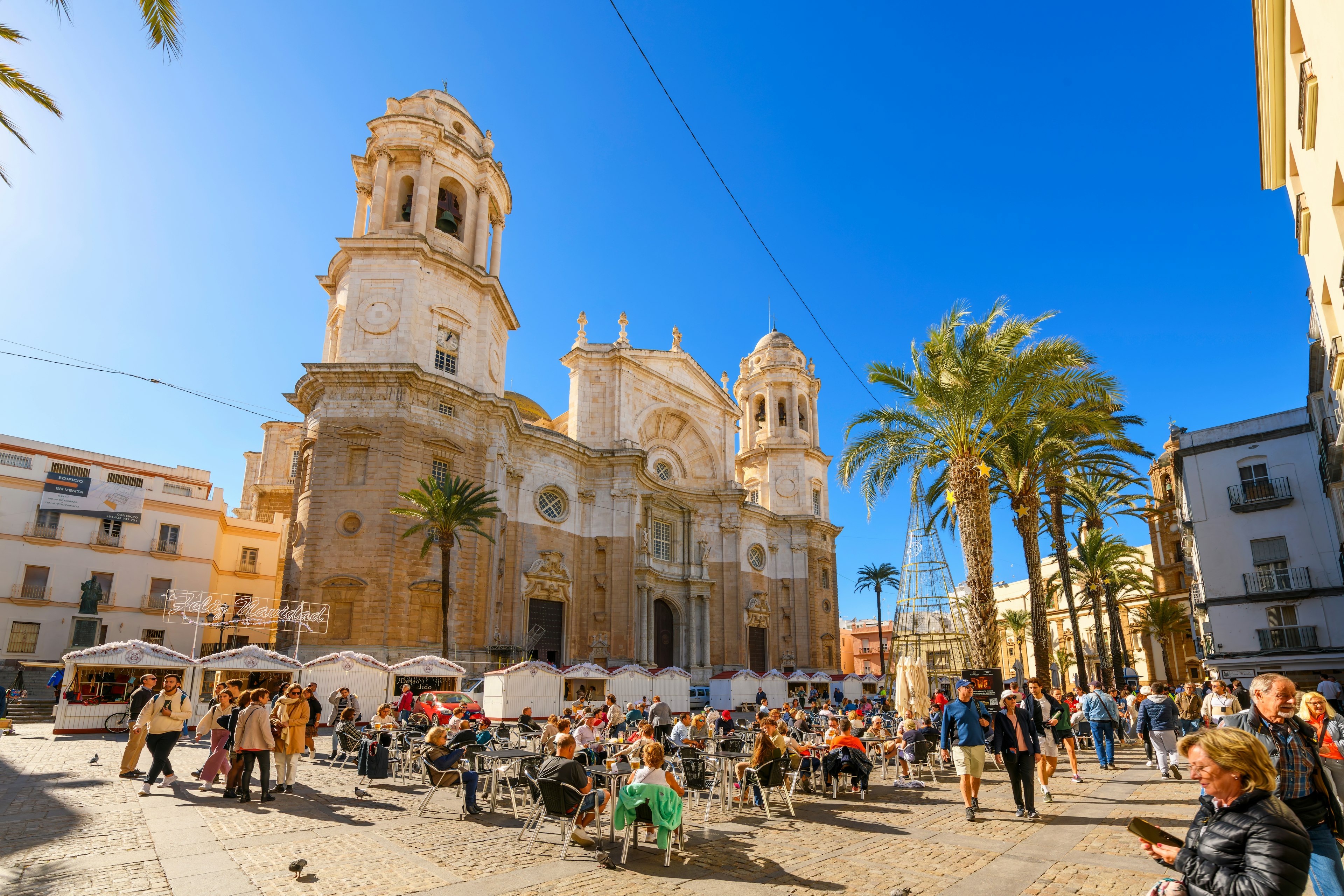 Tourists dine in the sun at the Plaza Catedral de la Santa Cruz de Cádiz, the main square in Cadiz, Spain.