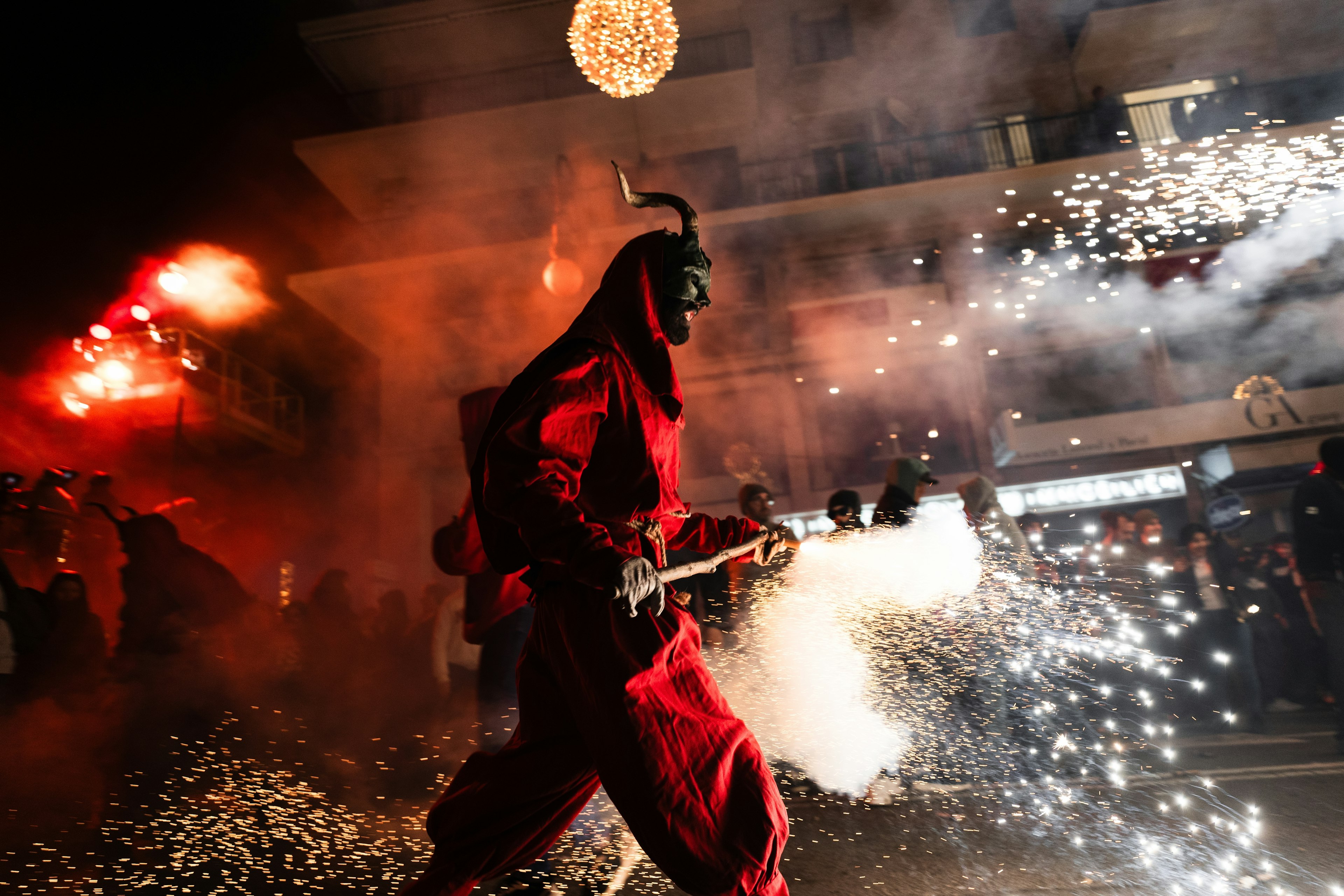 A man in a devil costume burning fireworks at Nit de Foc in Mallorca.