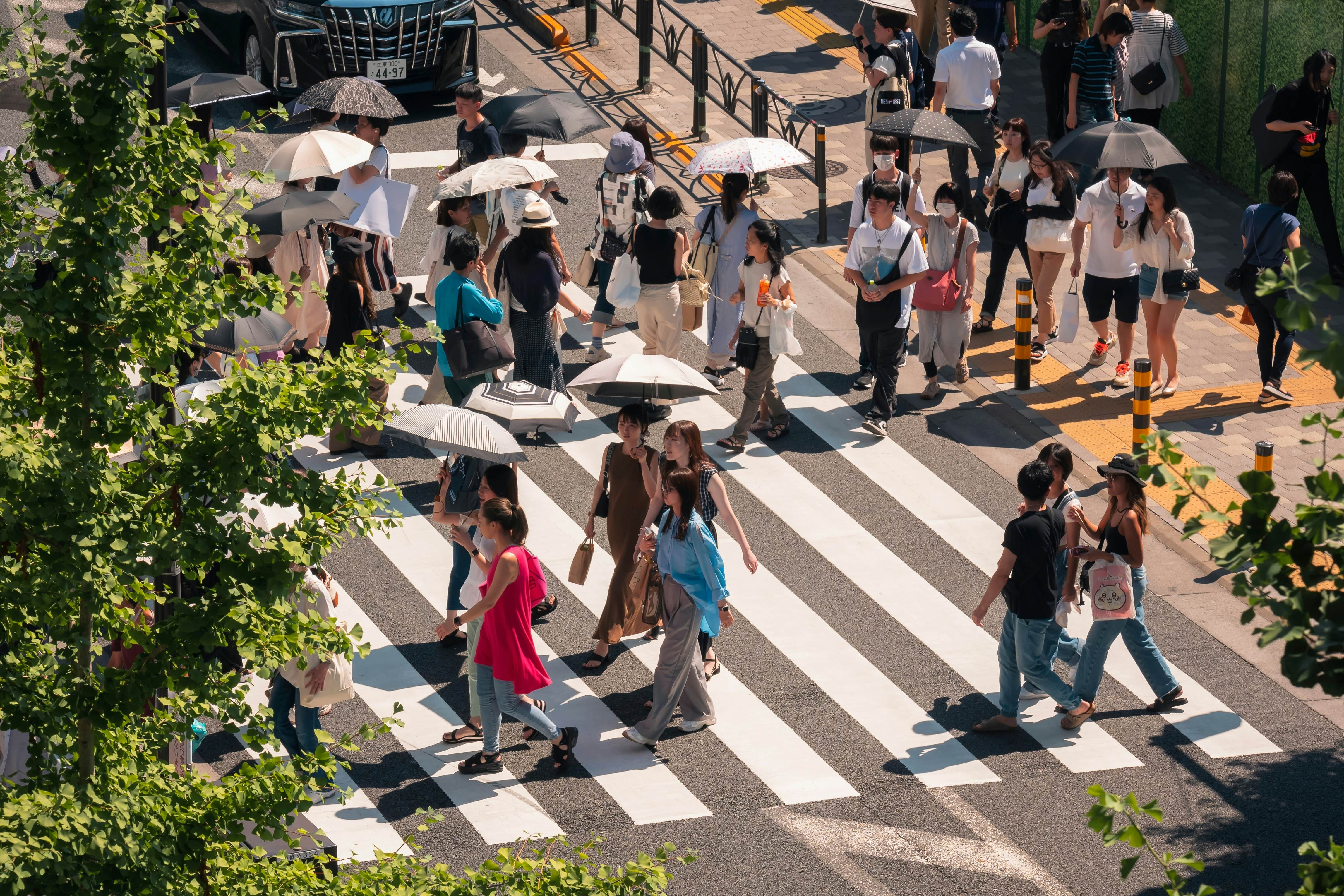 People walking on a crosswalk on a busy city street