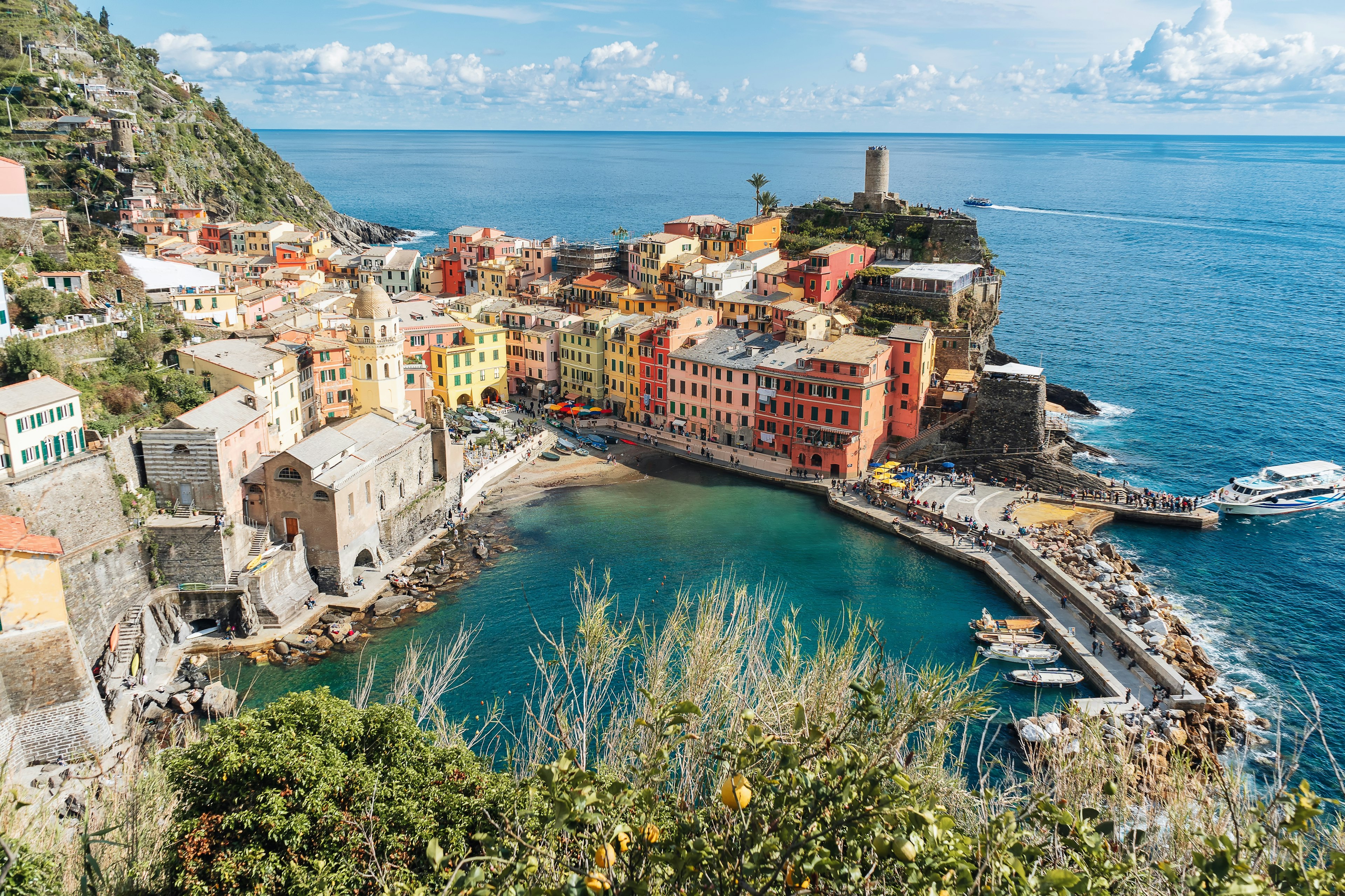 A seaside town of pastel-colored buildings glowing in the spring sunshine