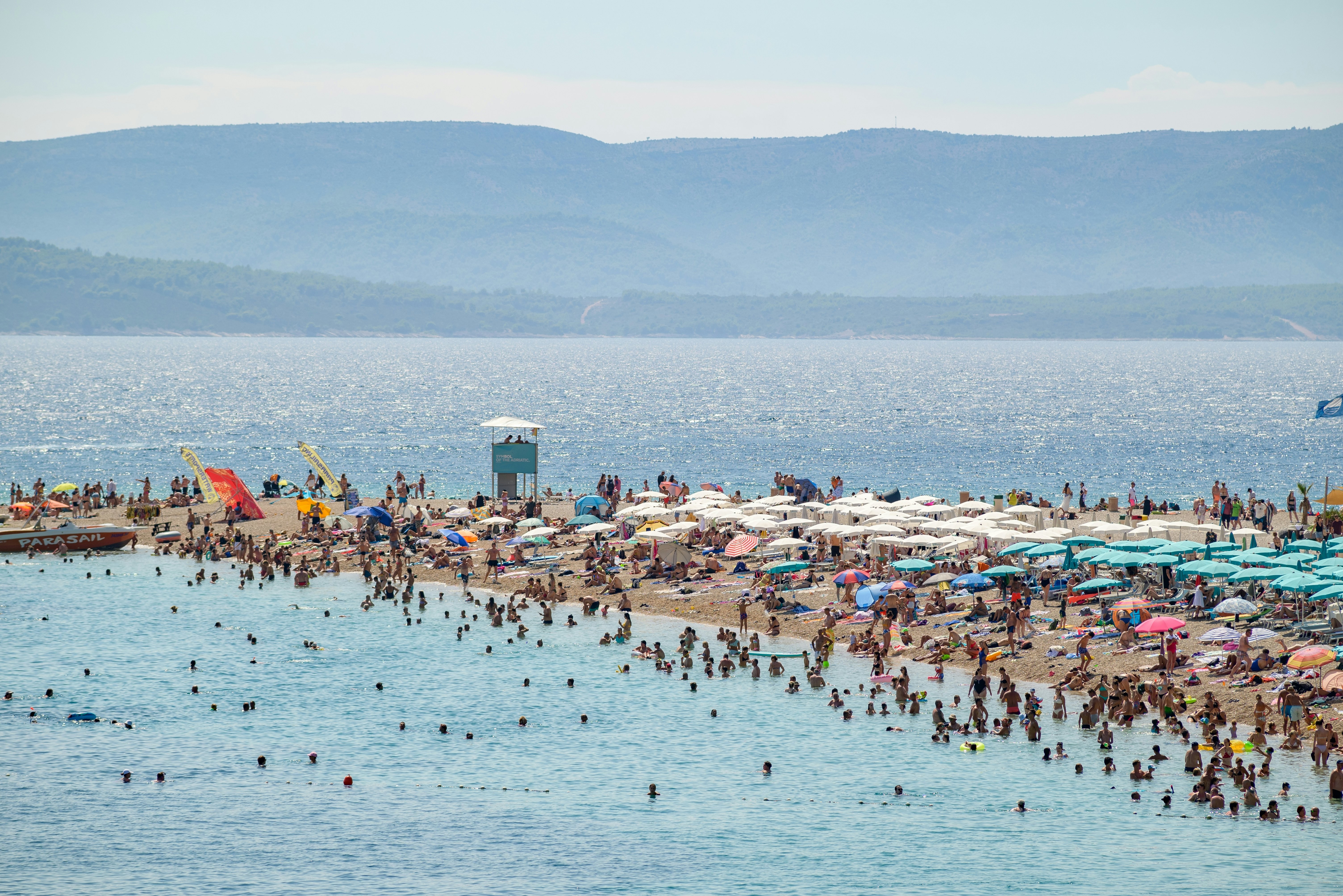 A busy beach day at Zlatni Rat on the southern coast of the island of Brac in Adriatic Sea.