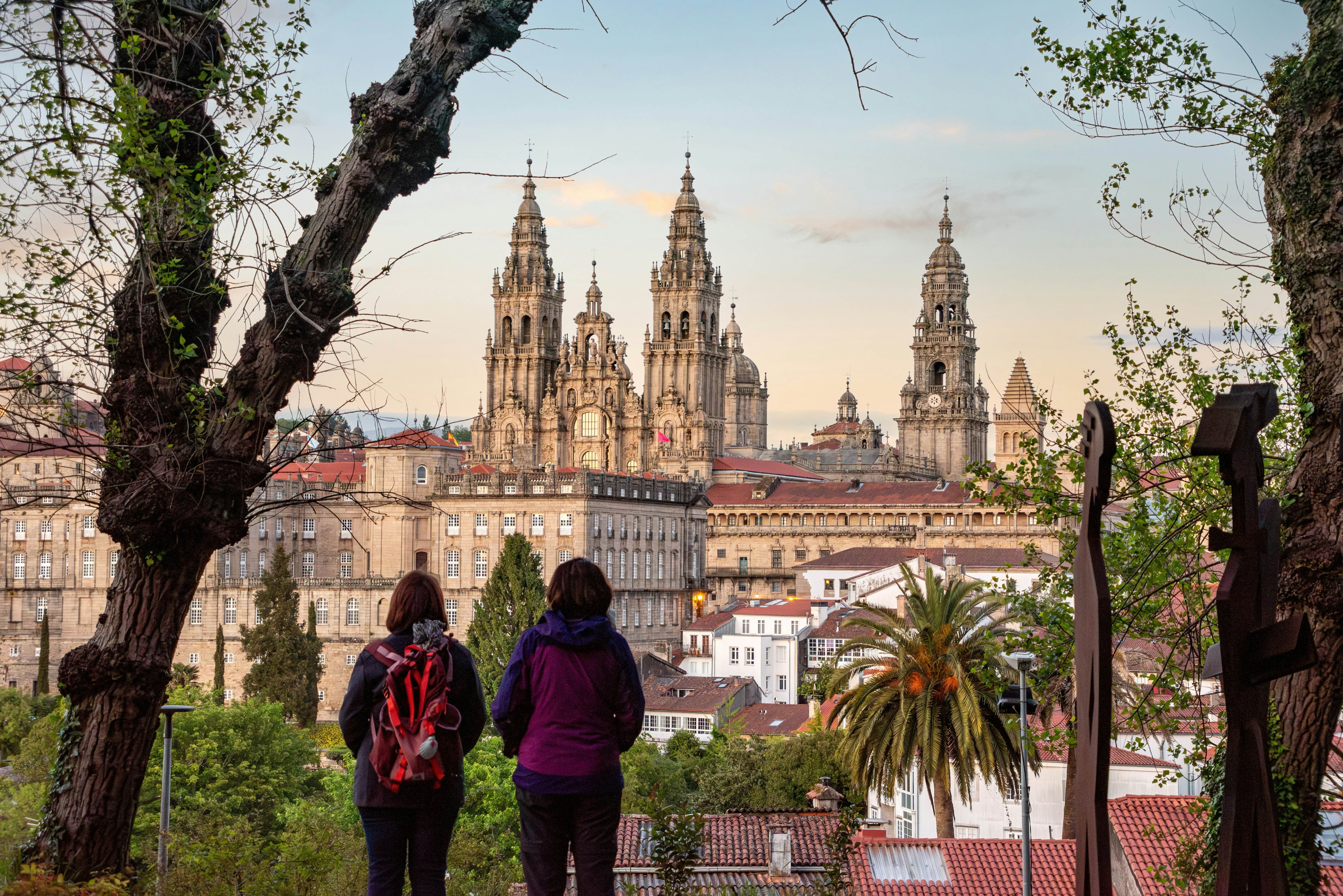 Pilgrims enjoying the sunset over Santiago de Compostela, seen from the famous cathedral viewpoint in the Alameda park.